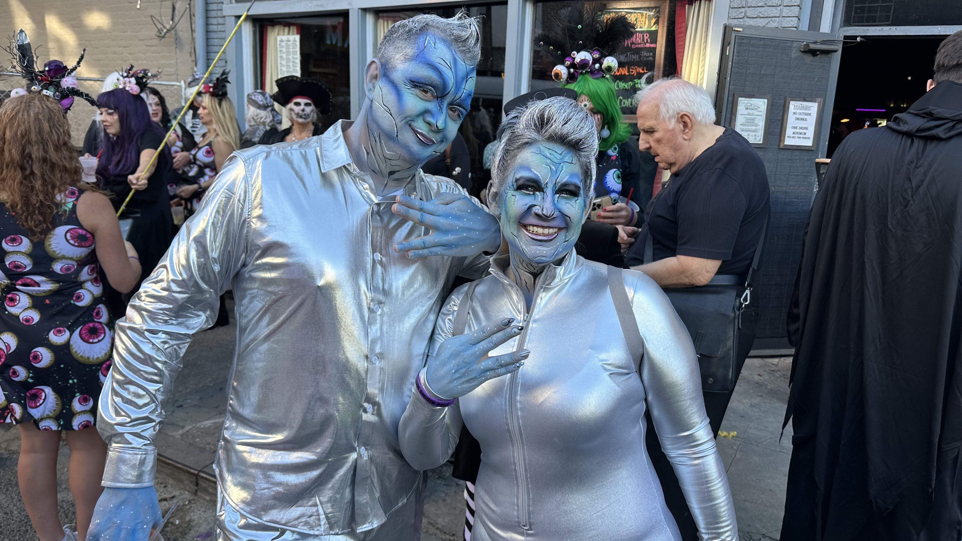 Image shows two people in silver costumes.