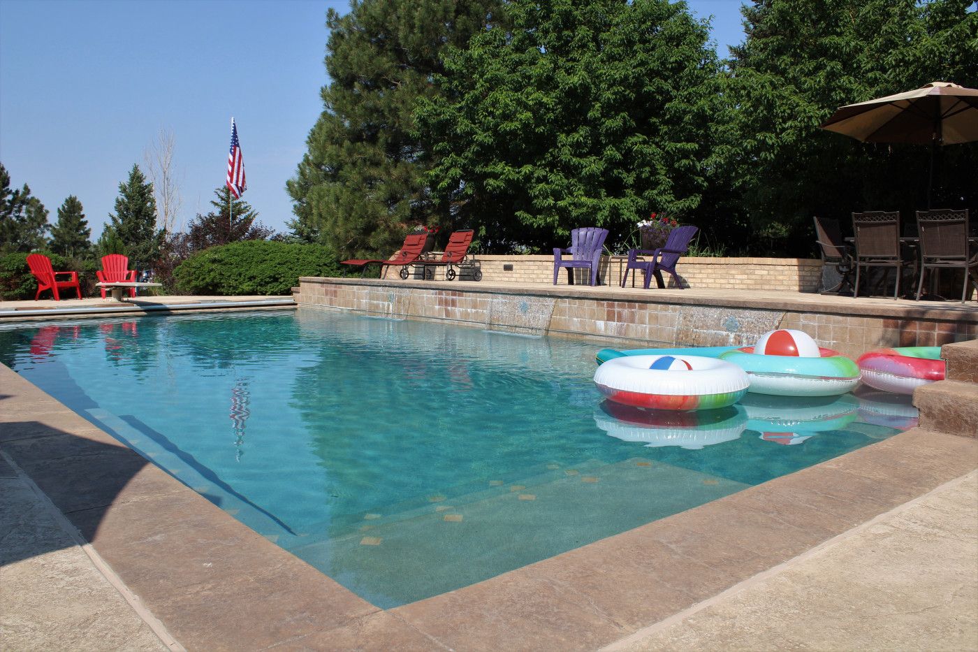 backyard pool with floats and chairs