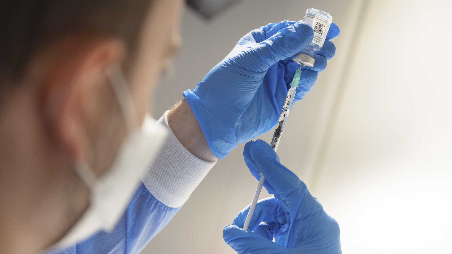 A helper draws up a syringe with Moderna vaccine in the pharmacy of the new vaccination centre.