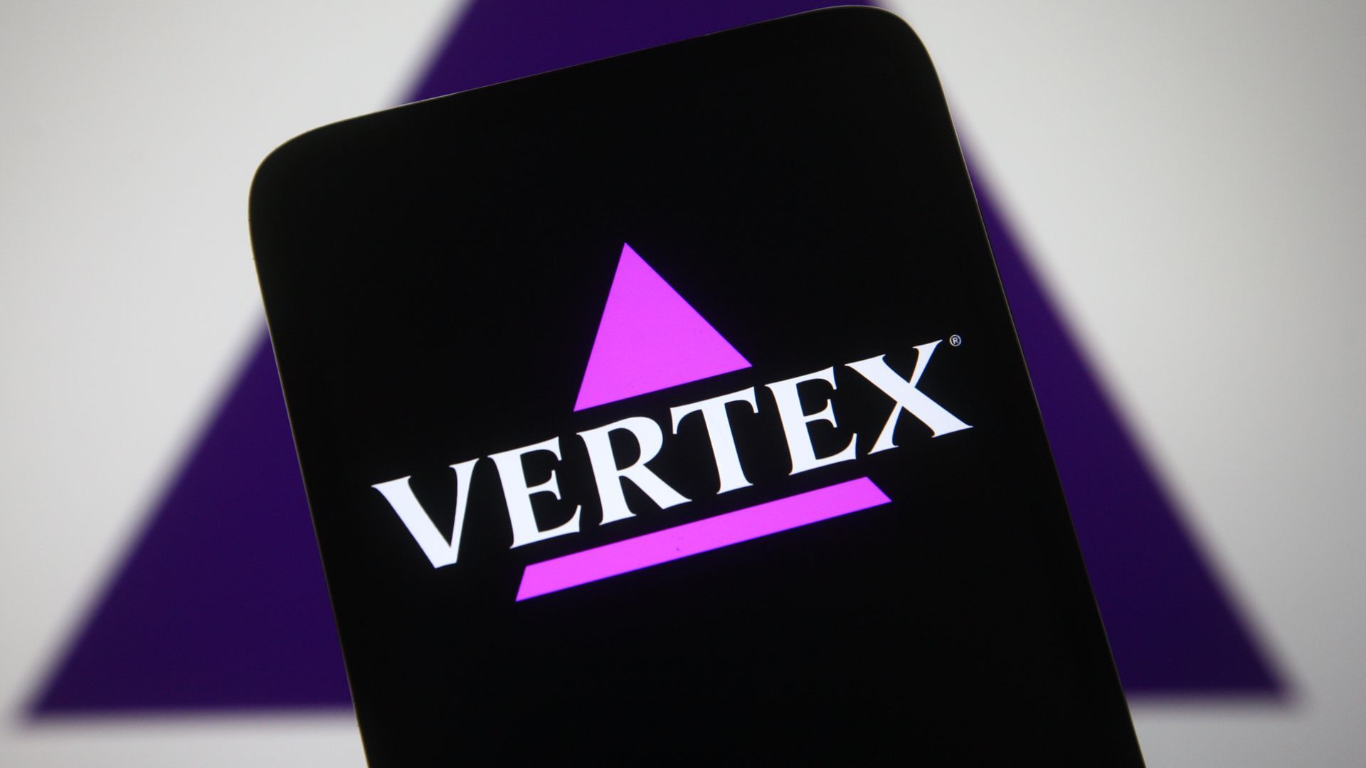 A photo illustration showing the Vertex logo on a smartphone.