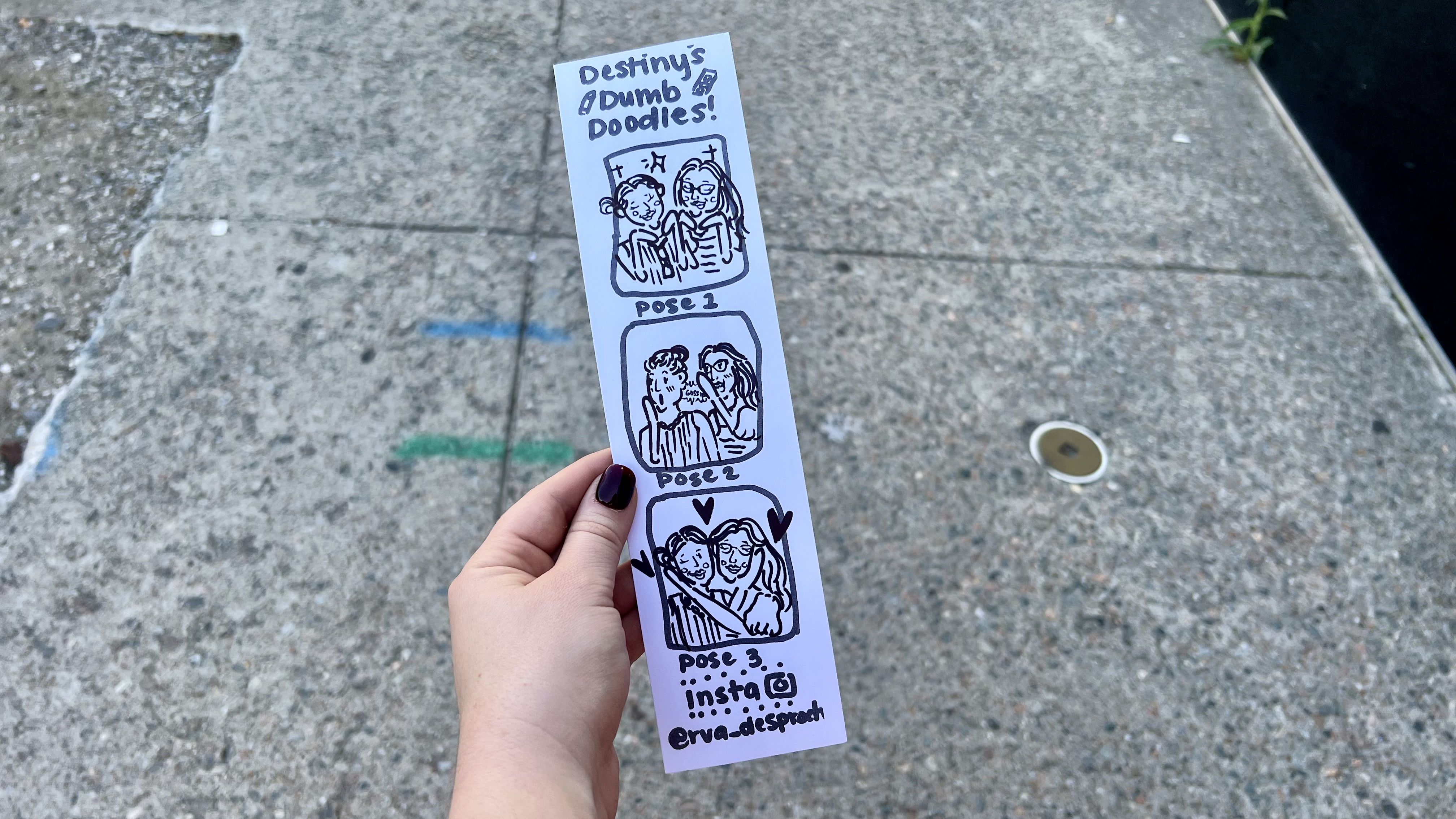 A hand with painted nails holds a white strip titled "Destiny's Dumb Doodles!" showing three black-ink cartoon poses of two people with hearts and Instagram handle @rva_desproche