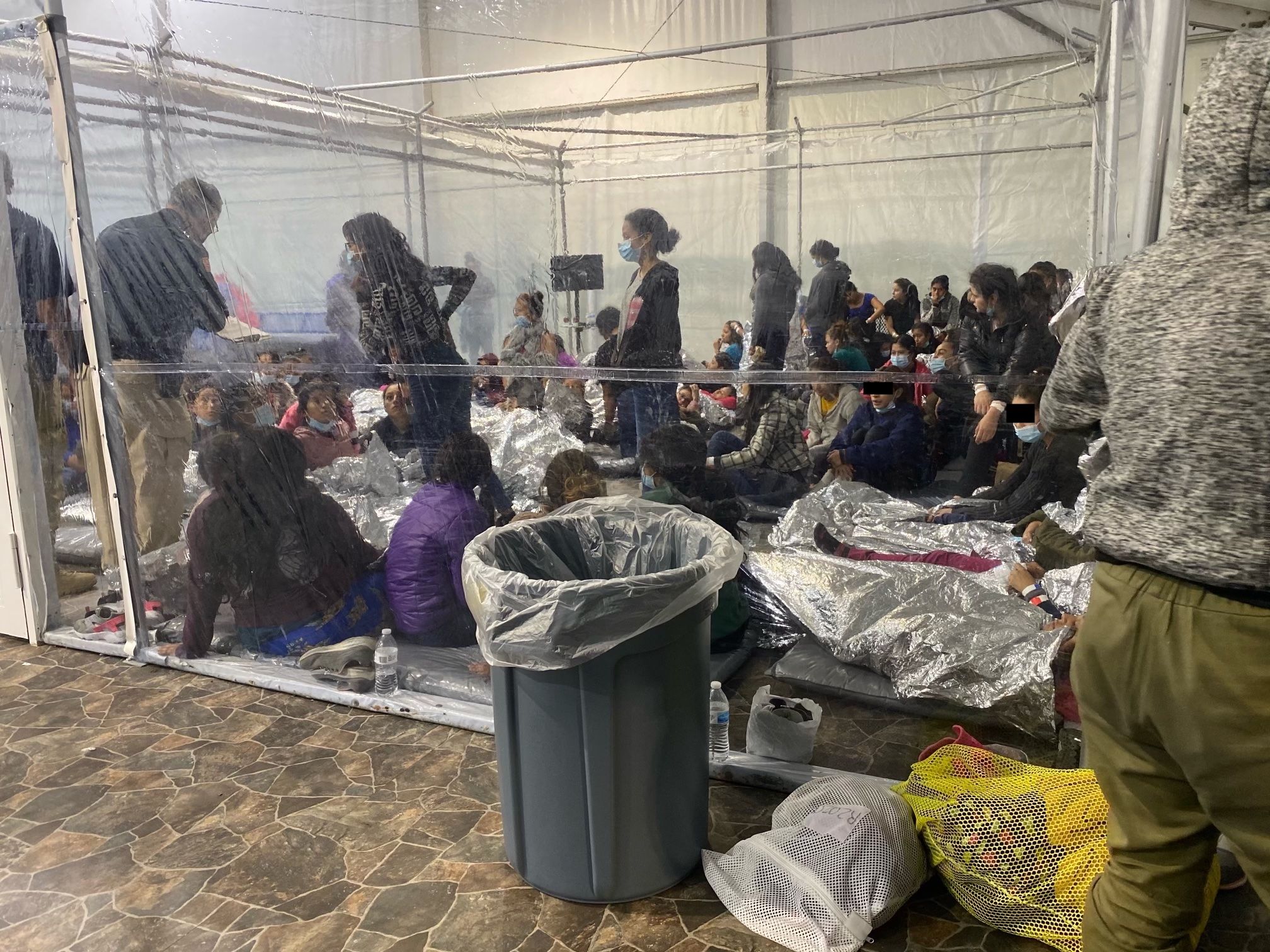 Migrants wait in an overflow border processing facility in March 2021