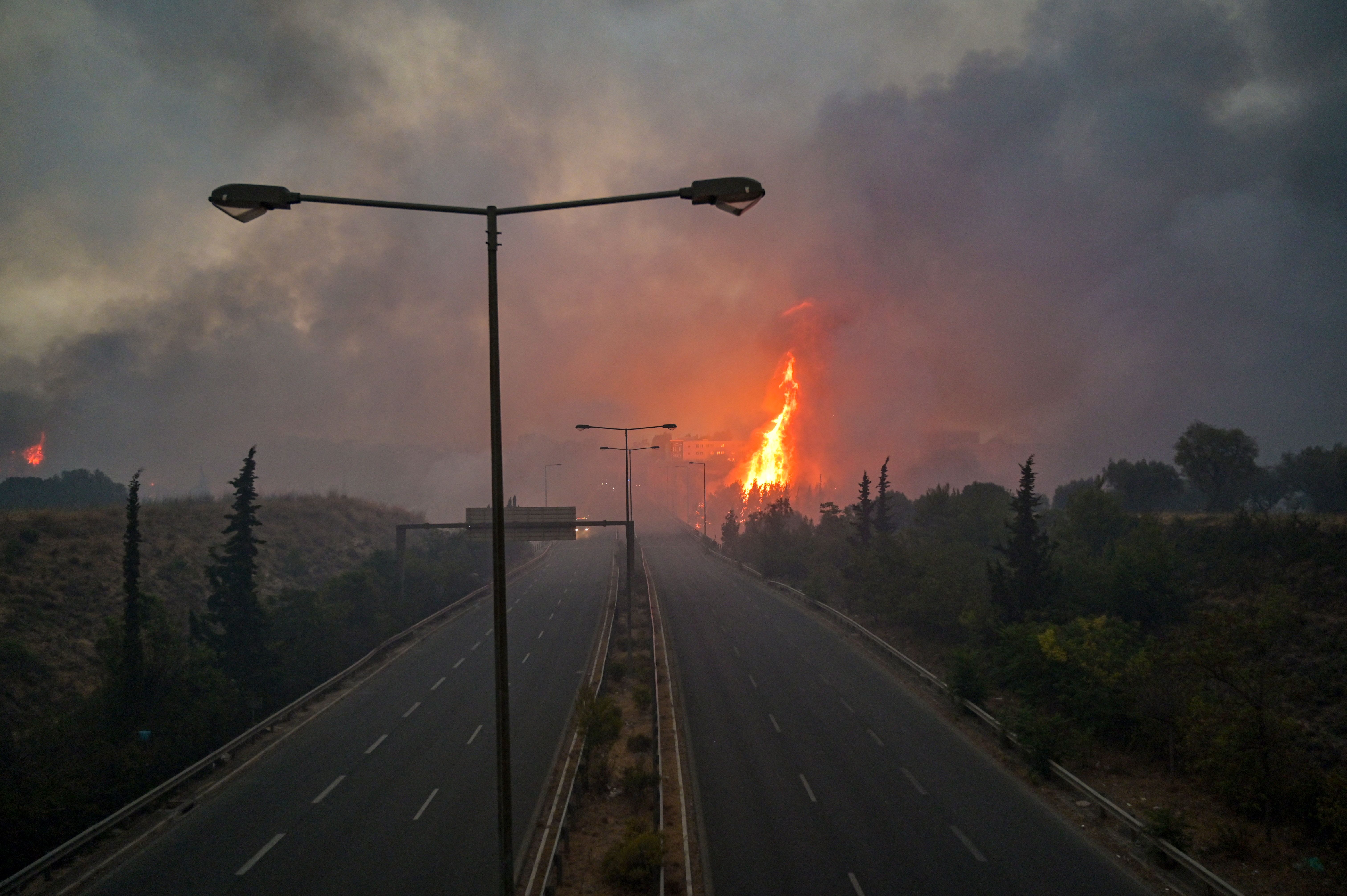 Picture of a road with a fire in the background