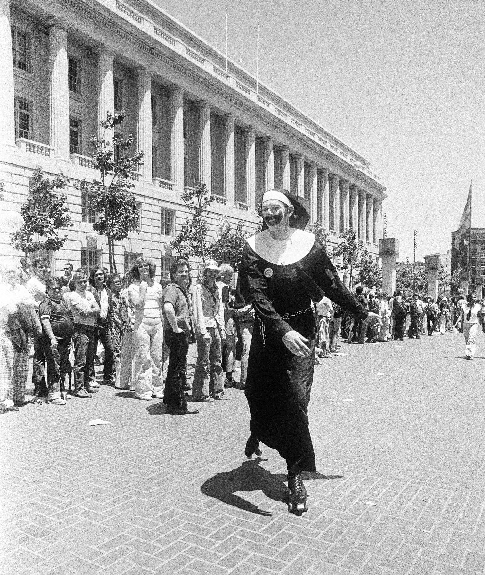 Photo of a person dressed as a nun rollerskating next to a crowd