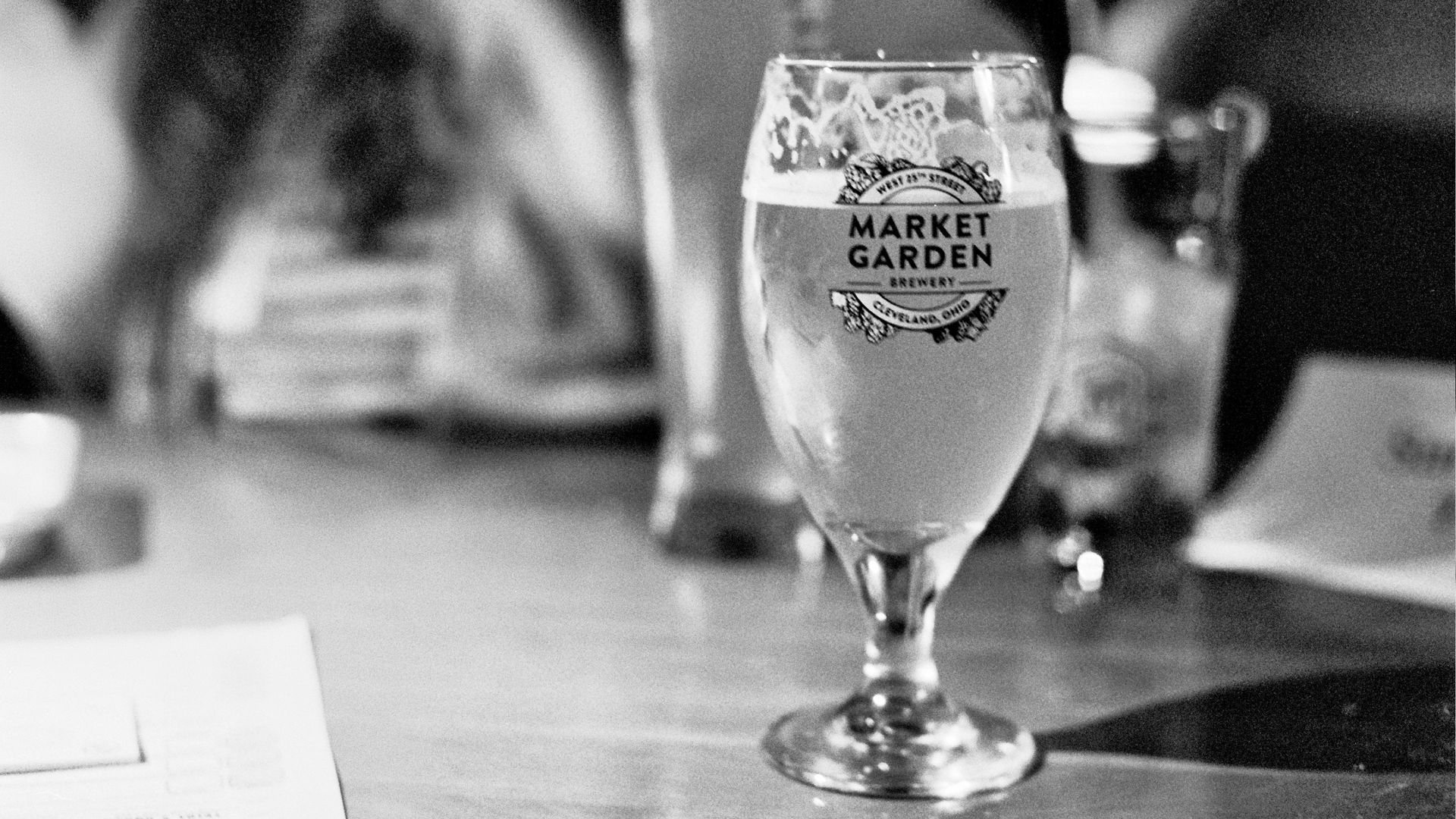 A goblet of Market Garden Brewery beer in a branded glass