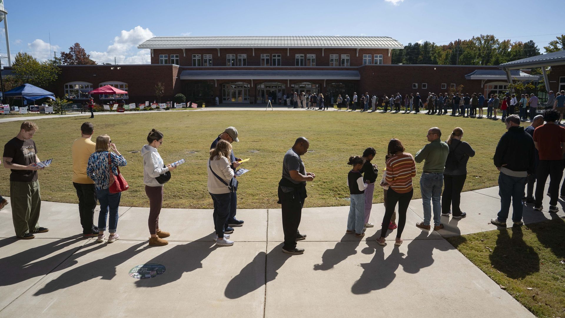 People wait in line to participate in early voting for the midterm elections on at 25, 2026 in Apex, North Carolina.