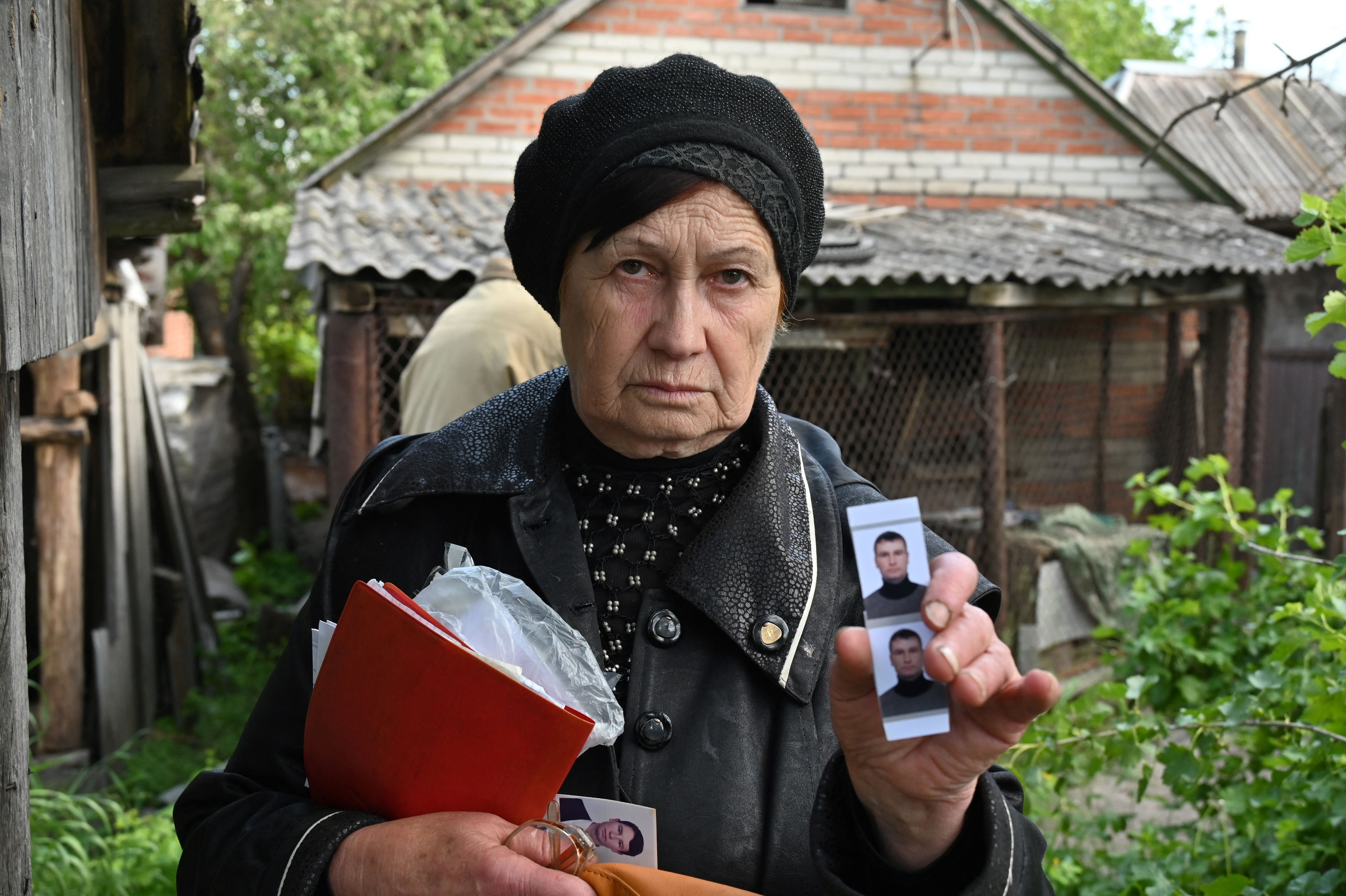  Olga Khomenko, 67, shows pictures of her son, who allegedly died when his car was hit by a Russian shell  in the village of Mala Rogan, near Kharkiv on May 23