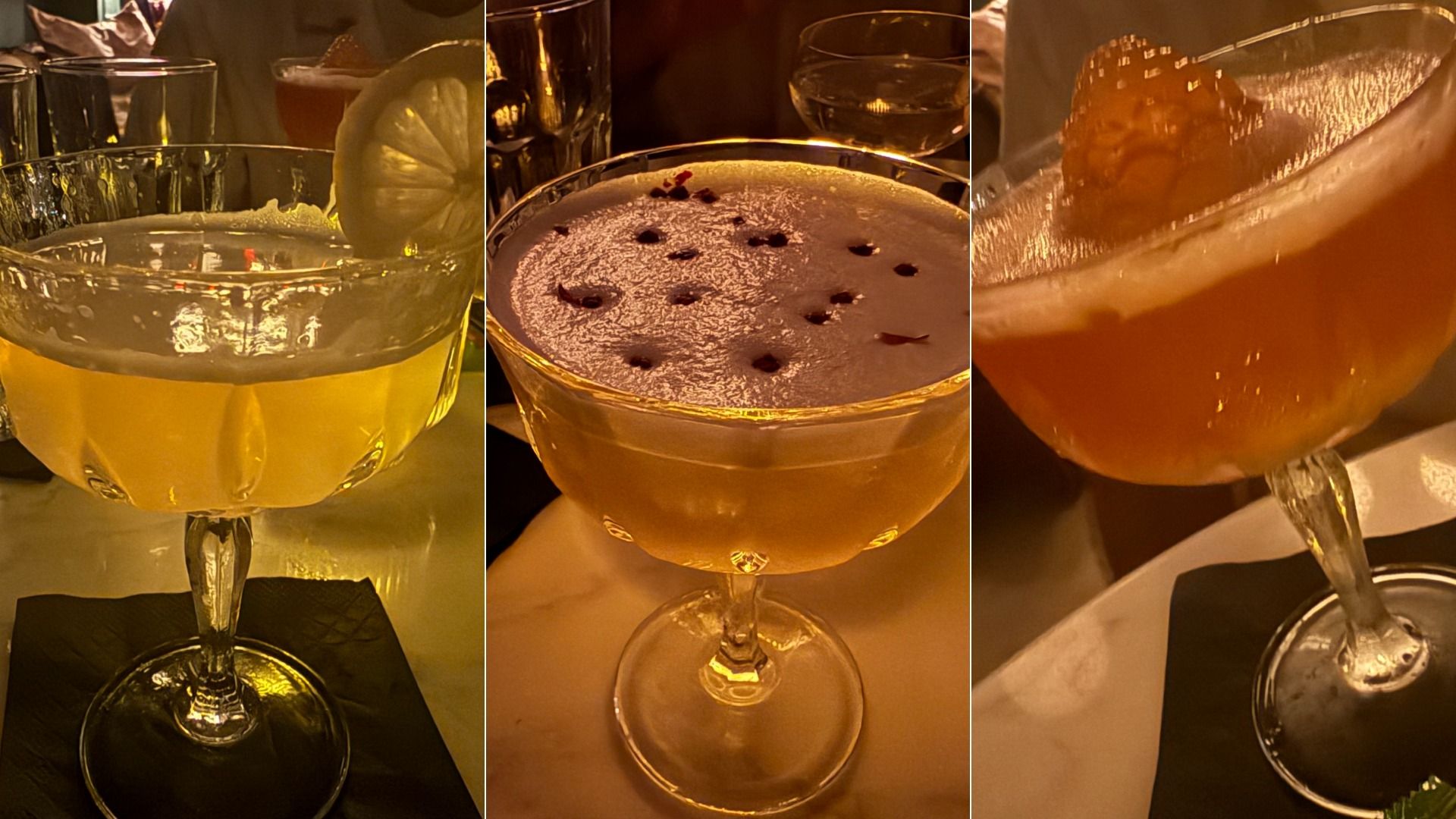 Three amber-colored cocktails in coupe glasses on a bar counter, each with distinct garnishes: lemon wheel, dotted foam, and crisp garnish, under warm lighting.