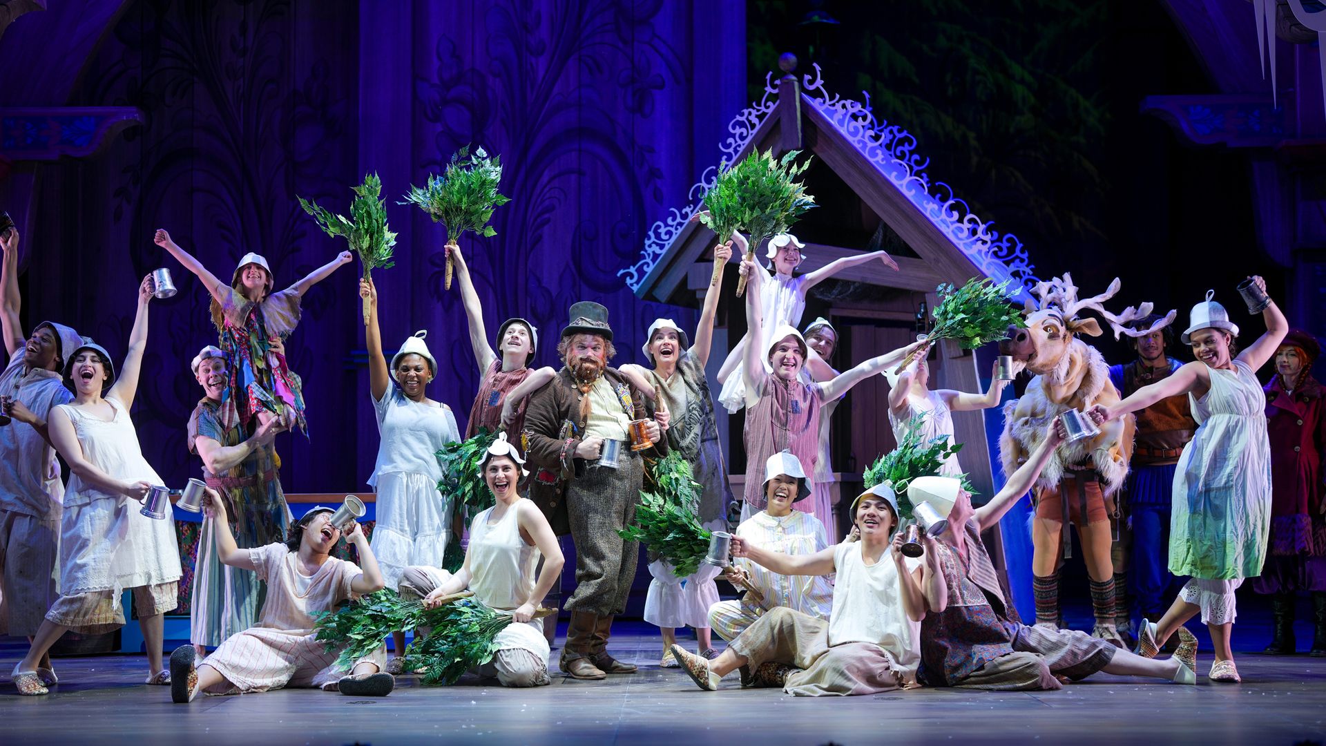 Actors in Frozen surround Oaken on stage
