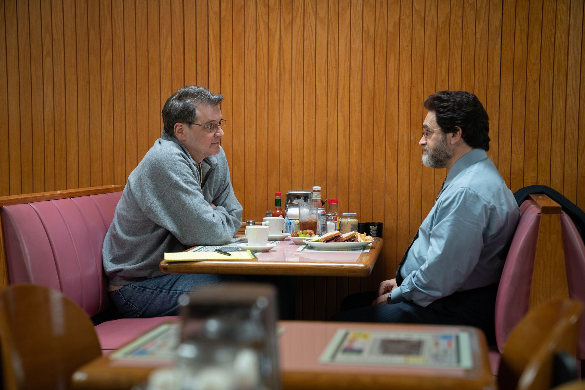 two men sit at a diner table
