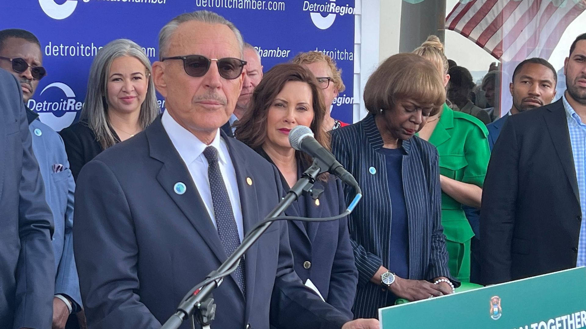 John Rakolta Jr. stands at a microphone.