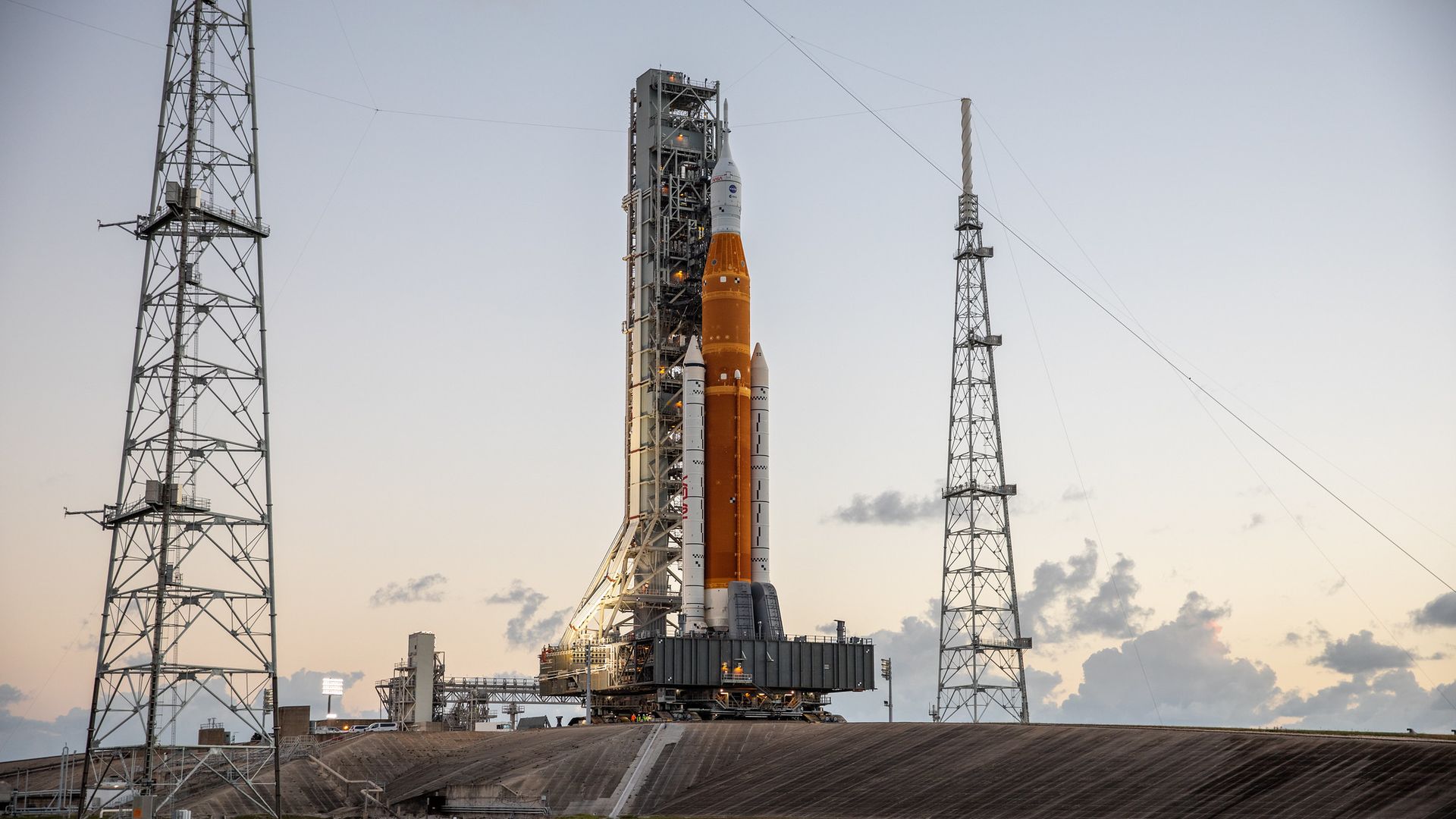 A white and orange rolling out to the pad at sunset.