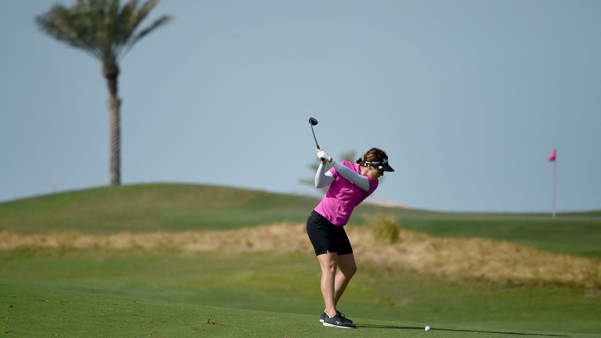 Woman plays golf.