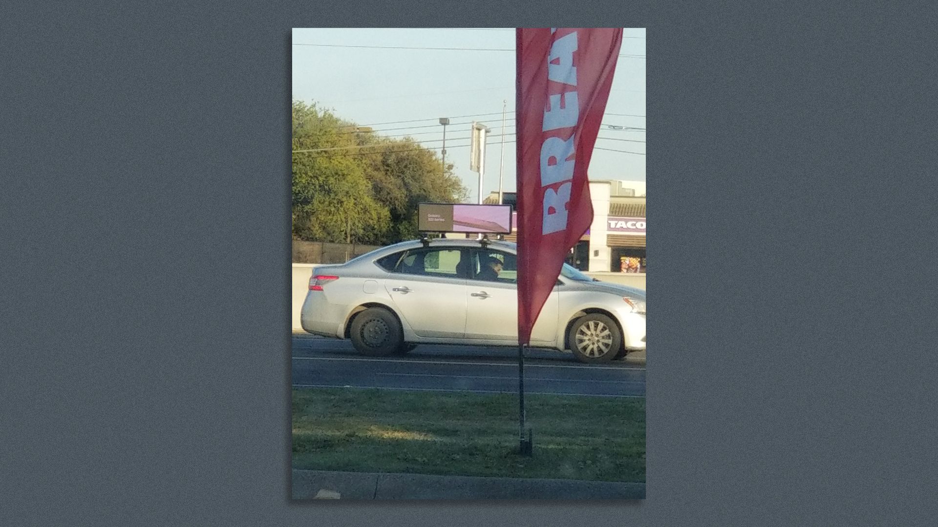 A car with an advertising banner on top.