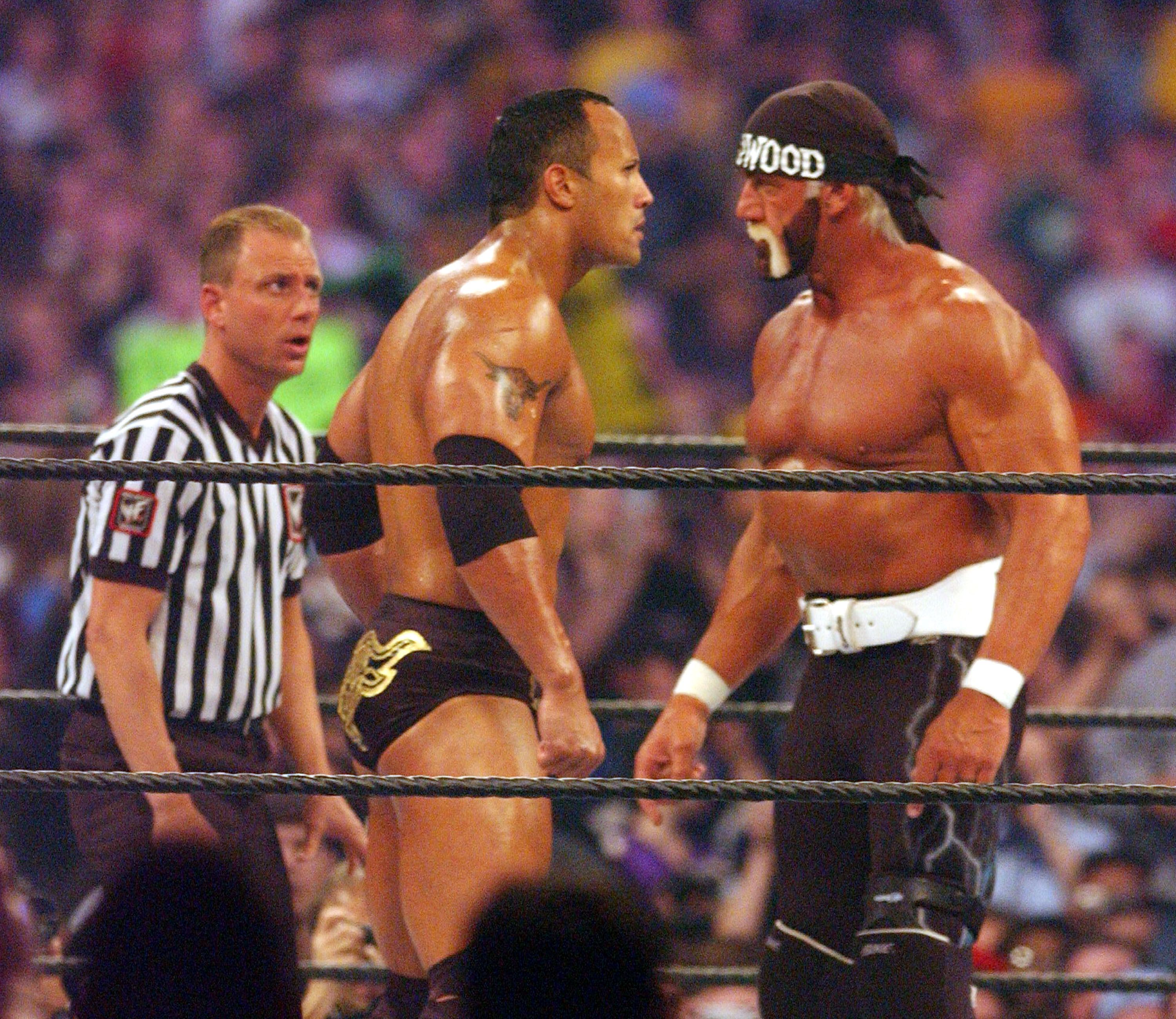 The Rock and Hollywood Hogan face off in a ring. 