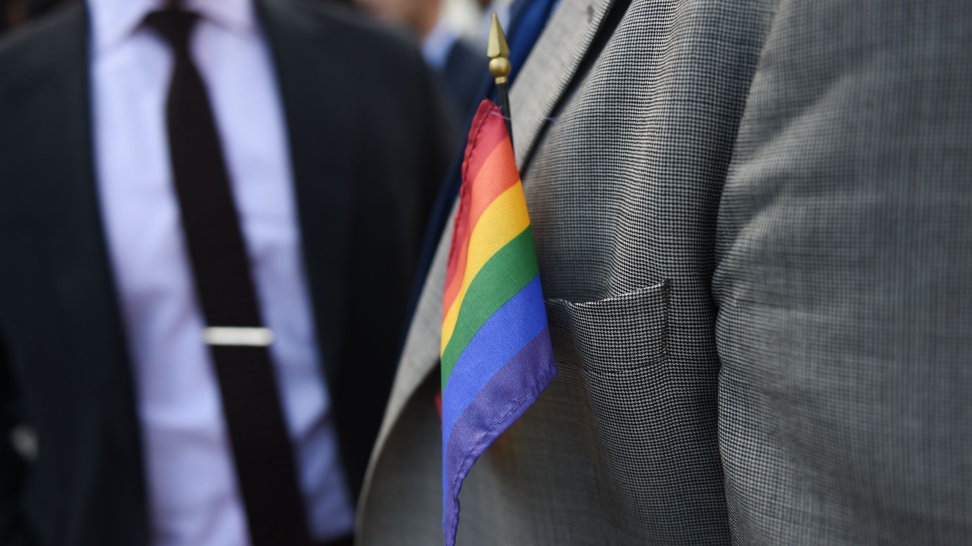 Photo of a rainbow flag sitting int he front coat pocket of a suit jacket