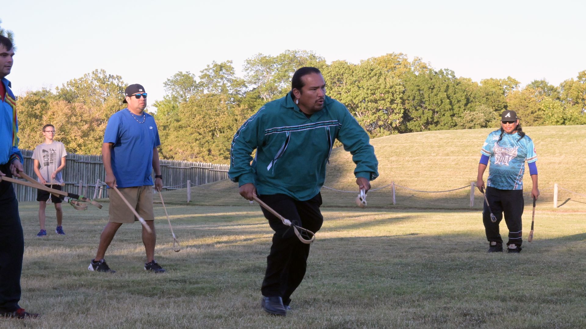 A man runs while carrying toli sticks used in the traditional native game of stickball