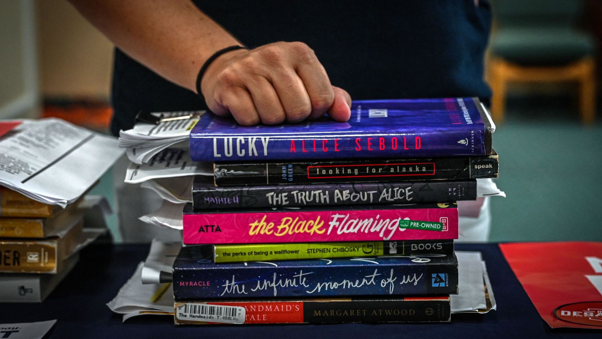 Jennifer Pippin, president of the Indian River County chapter of Moms for freedom, attends school board member's campaign event in Vero Beach, Florida on October 16, 2022, while placed her hand on library books she opposes.