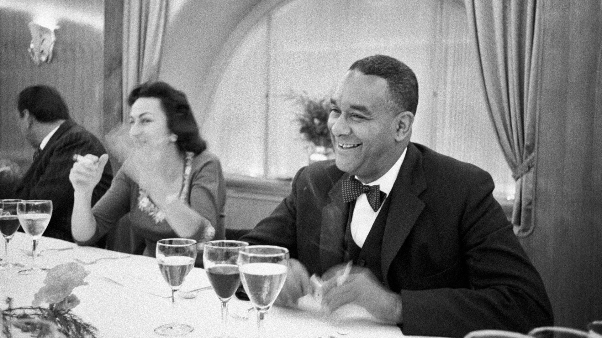 American writer Richard Wright sitting at the table and smiling during his visit to Italy for the publication of the book Black power. Milan, 1957.