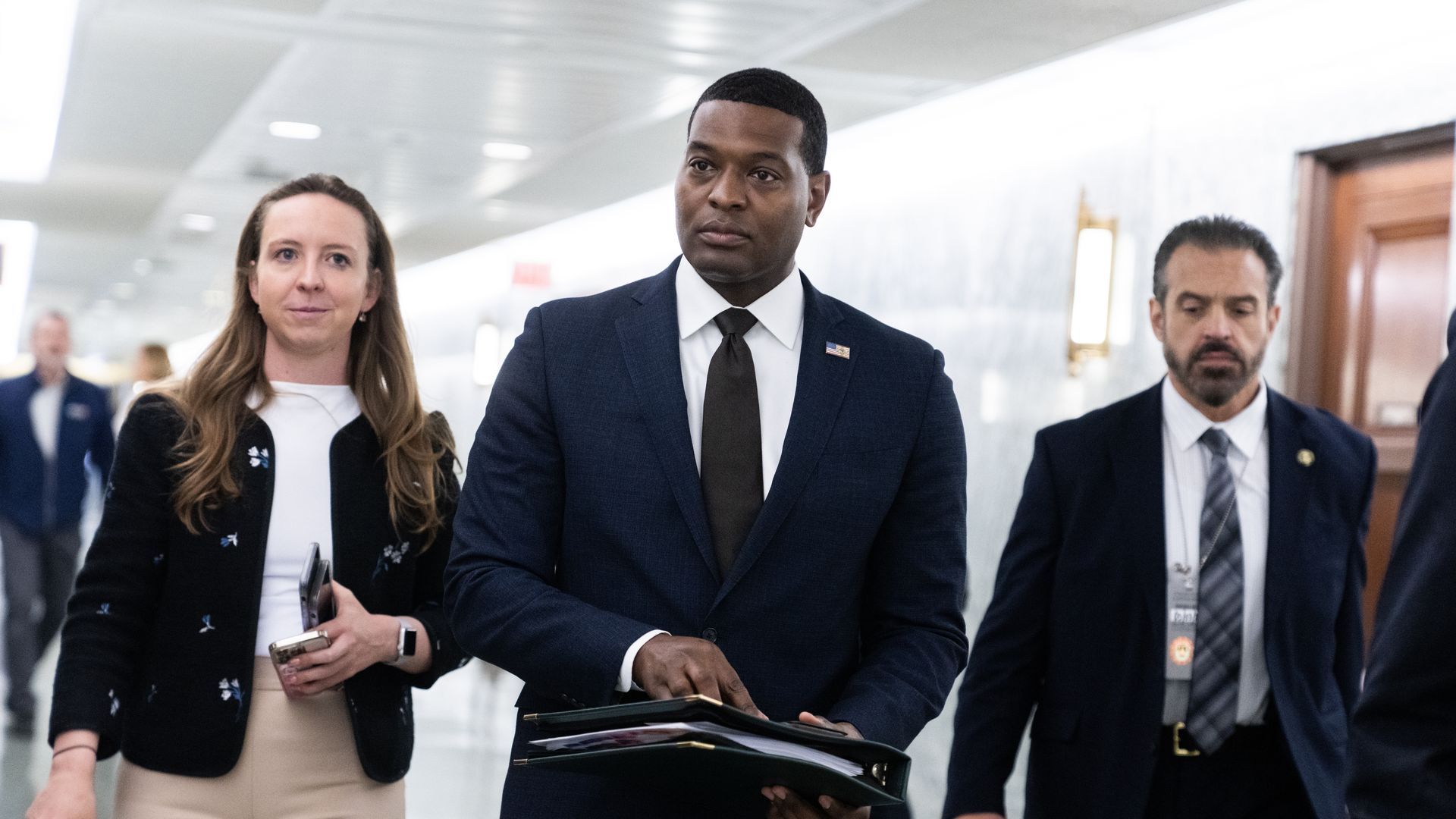 EPA Administrator Michael Regan and a group of people walking in a hallway