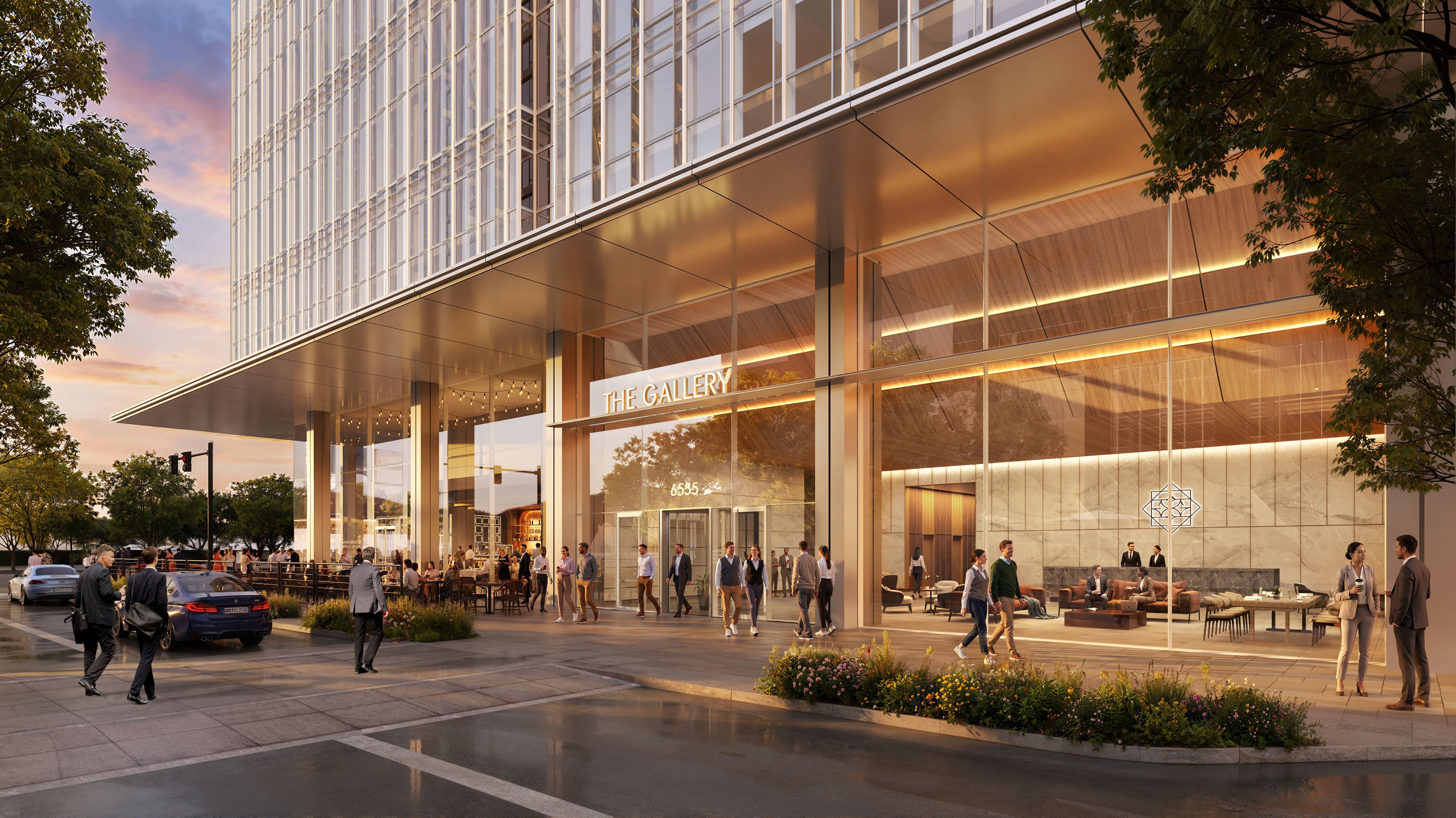 Modern glass building at sunset with a storefront sign reading "THE GALLERY". People walk a lit patio outside, warm interior light visible through glass, framed by trees and street traffic.