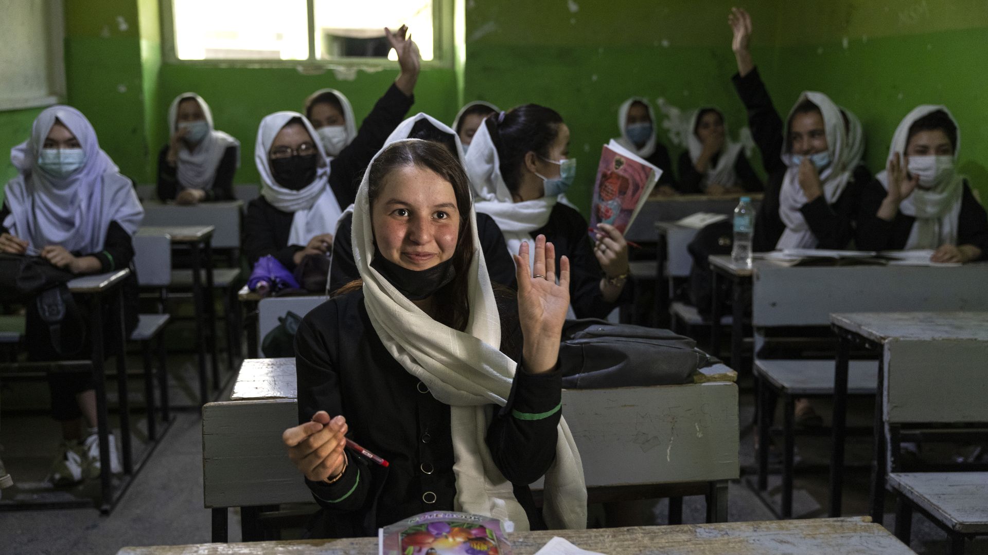 Zinat Karimi, 17, raises her hand during 10th-grade class at the Zarghoona high school on July 25 in Kabul, Afghanistan