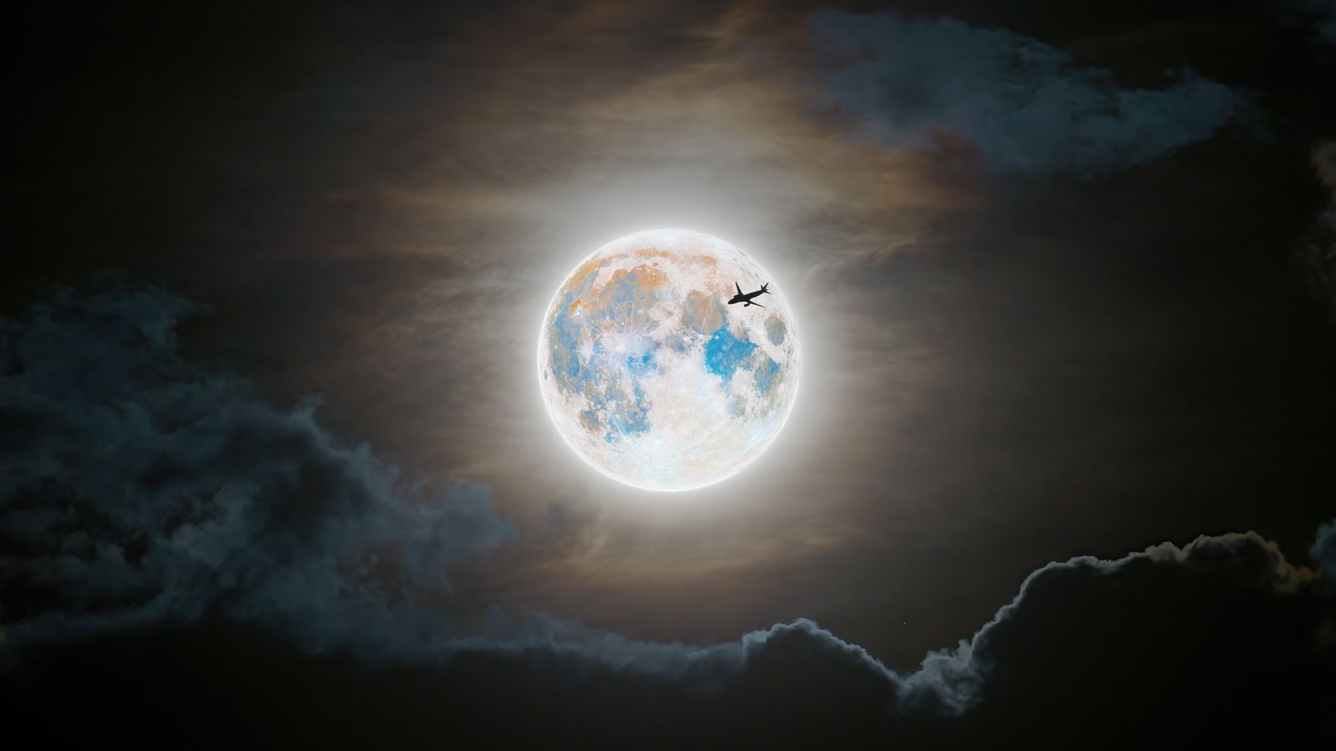 A blue moon with an airplane silouhette. 