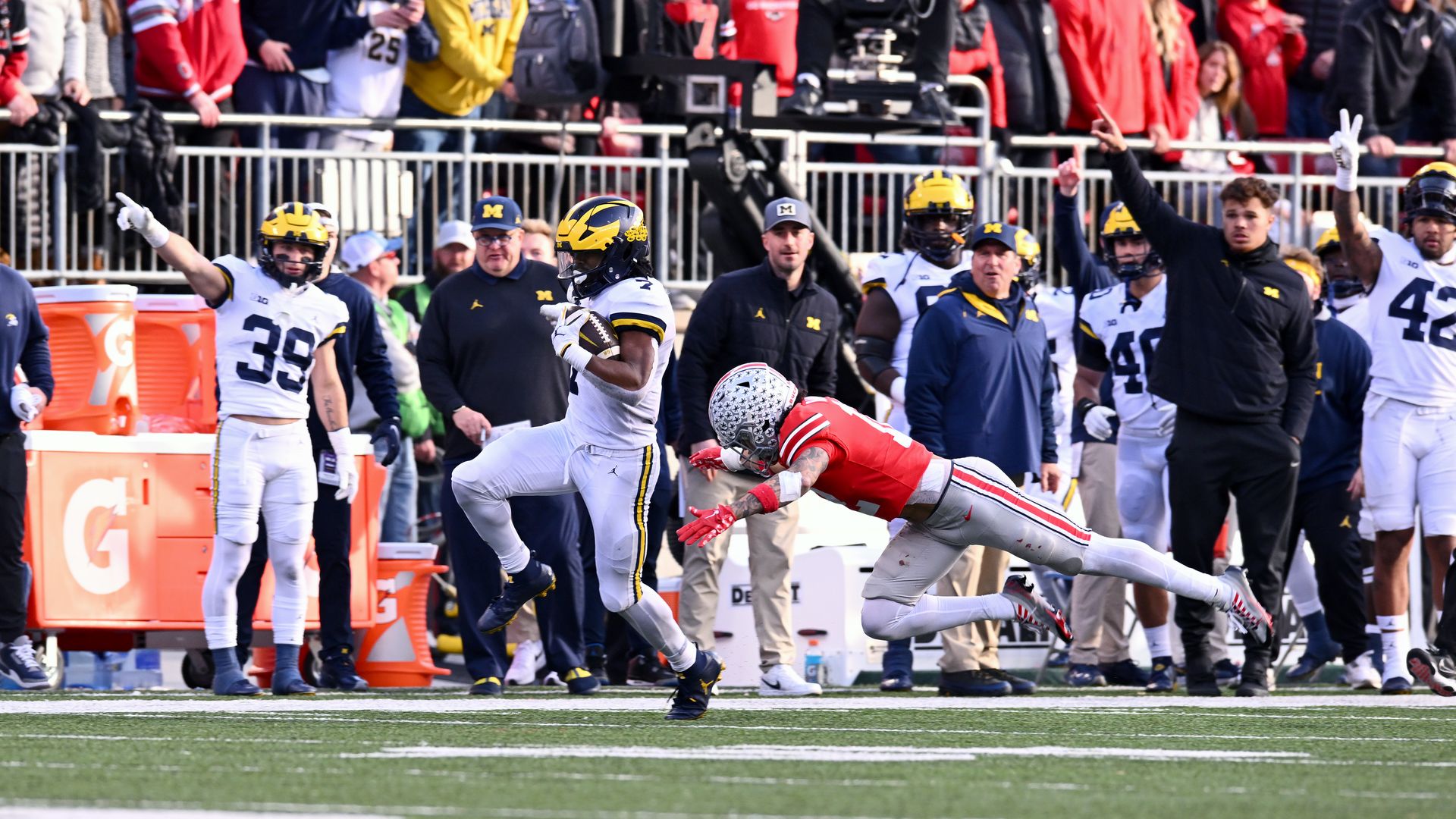 A Michigan football player evades an Ohio State tackle. 