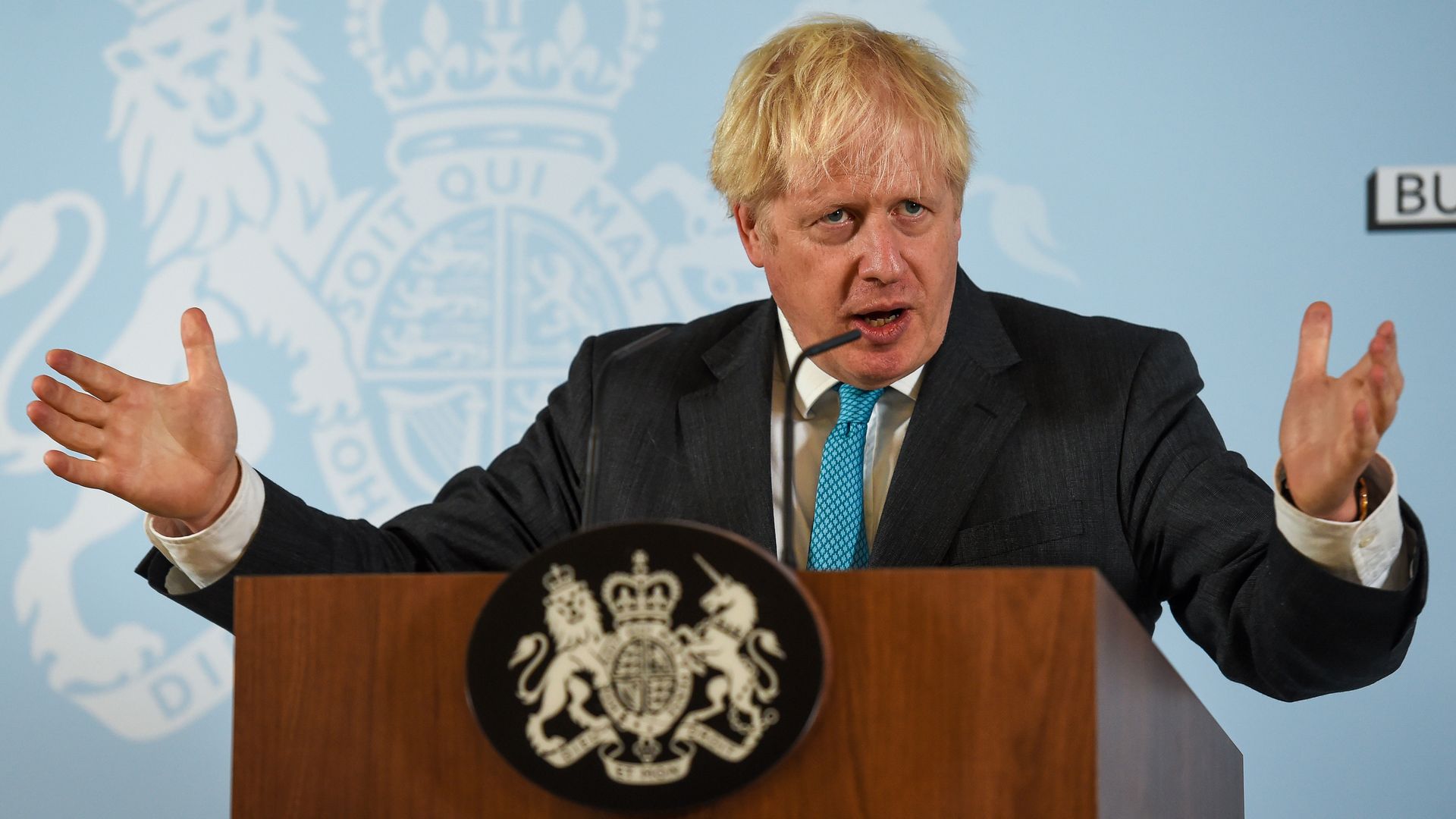 Boris Johnson stands in front of a podium