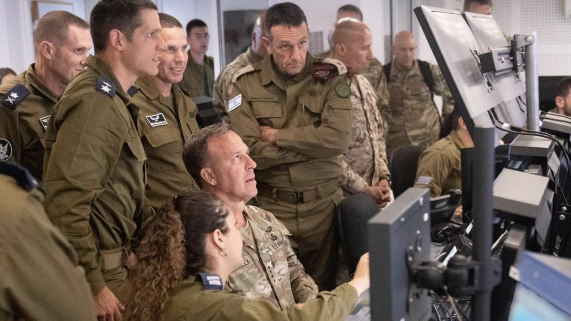 U.S. Gen. Michael Kurilla surrounded by Israeli soldiers in front of a computer.