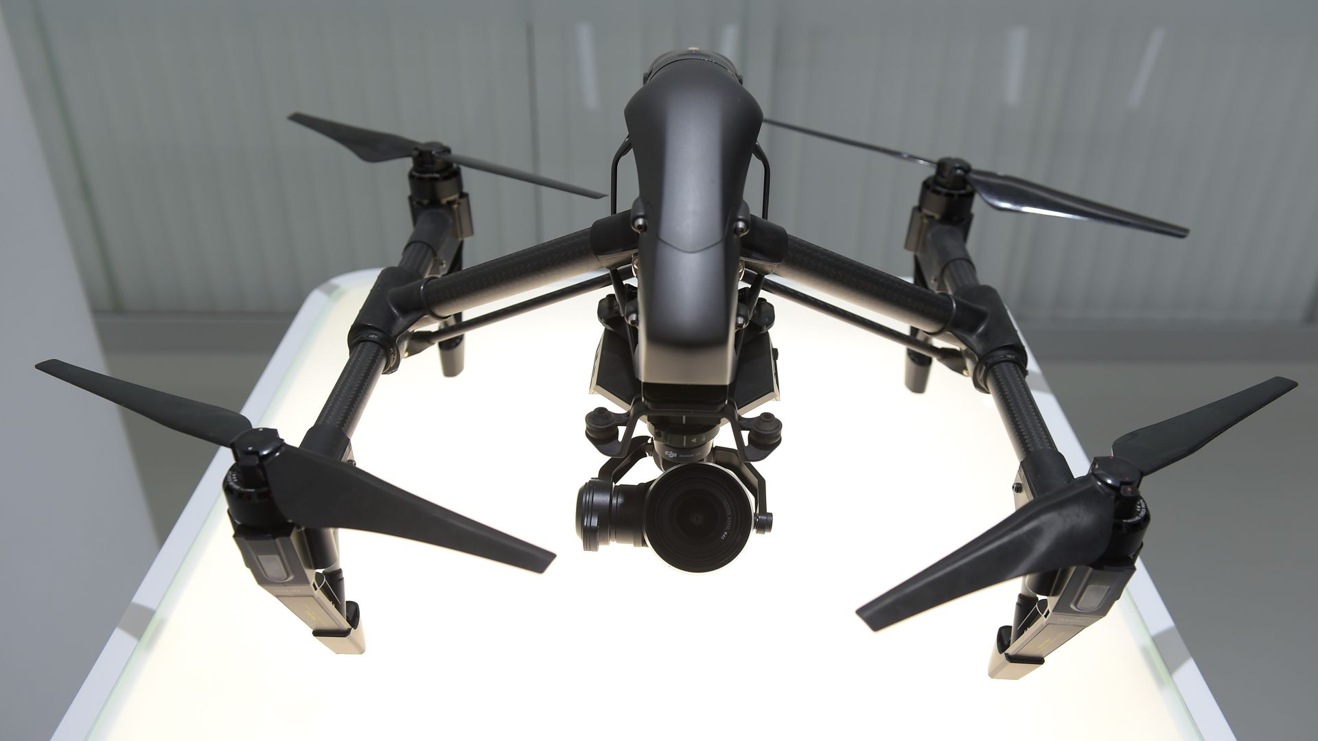 black commercial quadcopter drone, sitting on pedestal