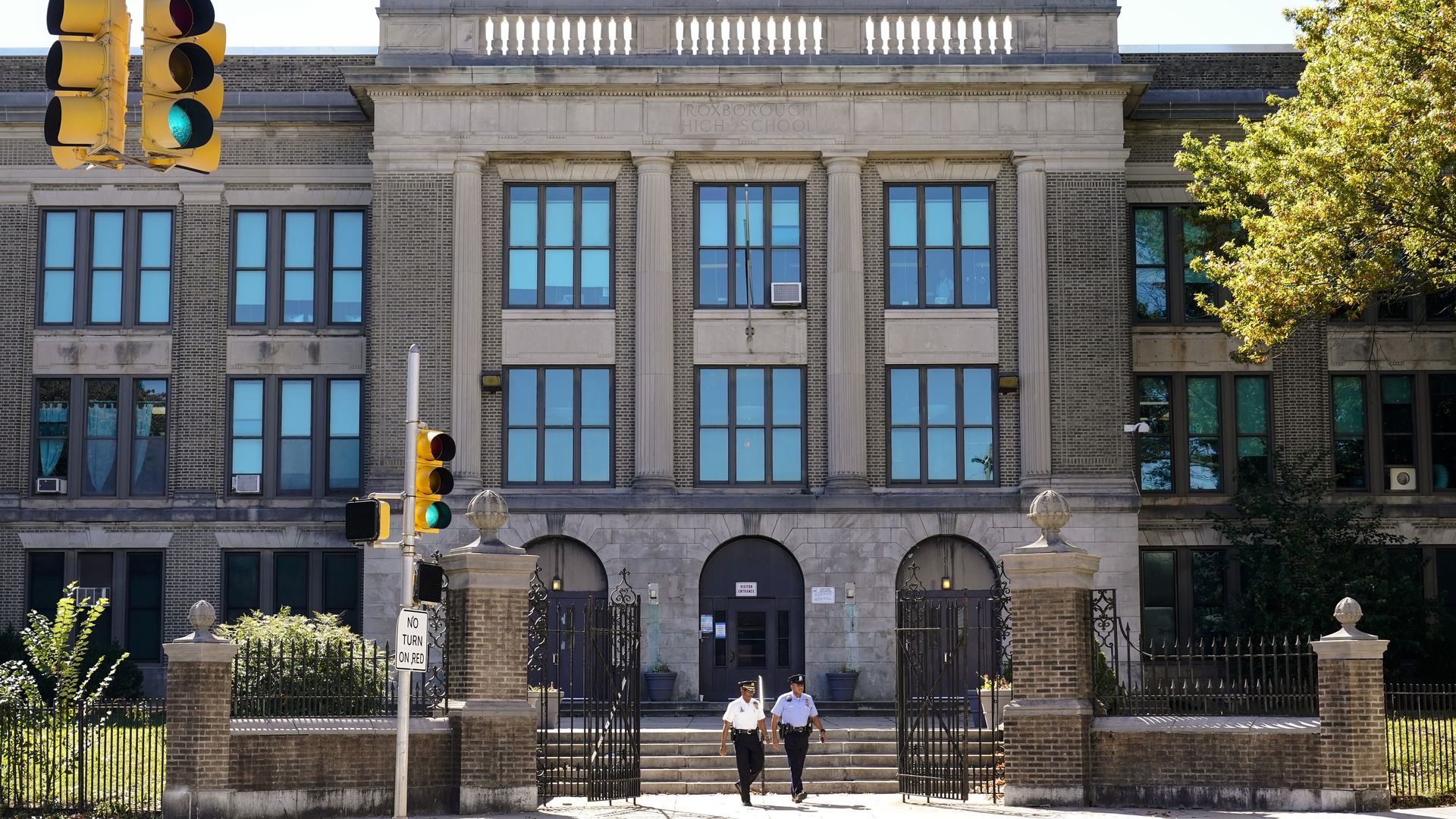 Police officers walk from Roxborough High School.