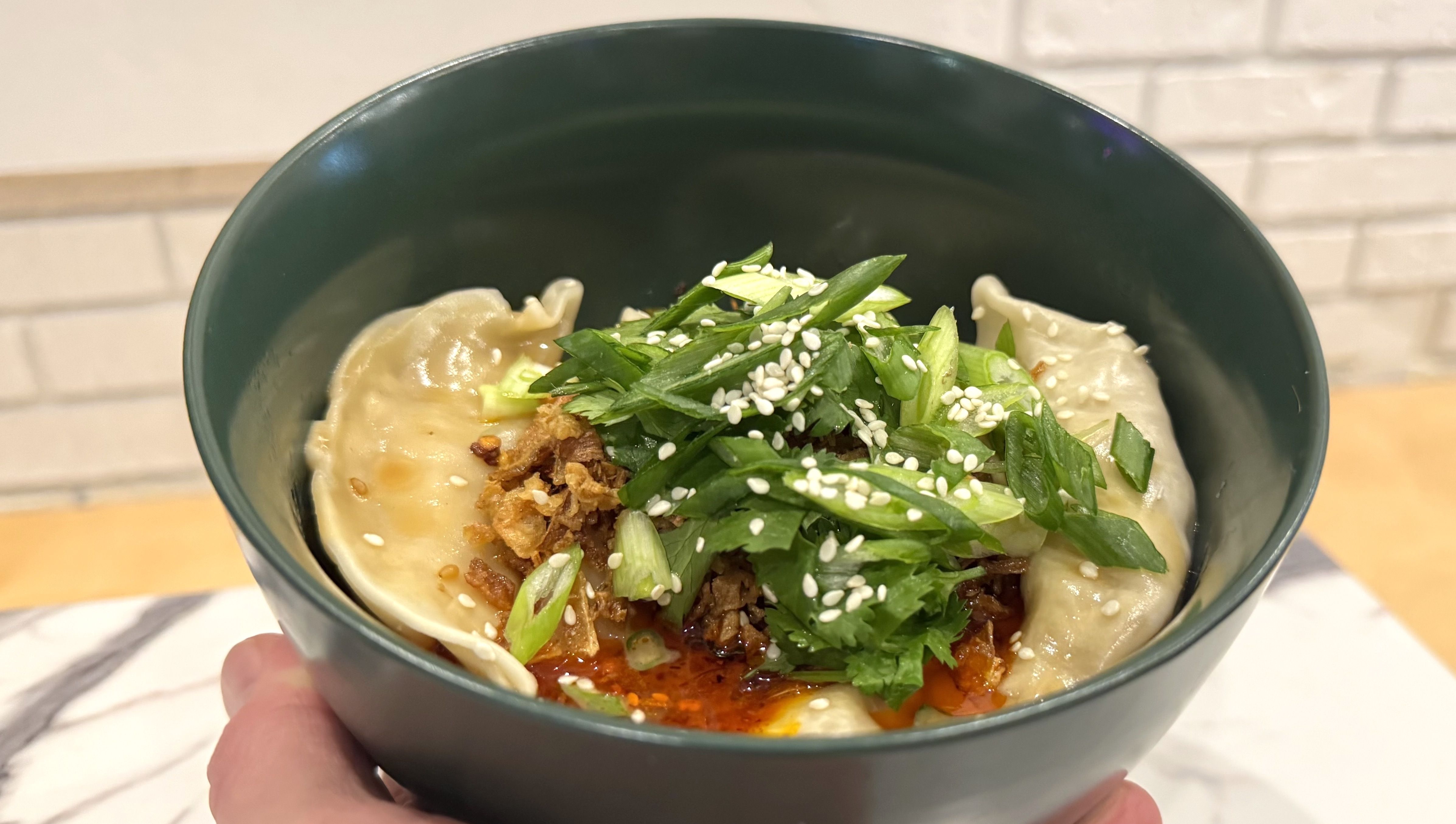 The sichuan dumplings ($9) with chicken, served in a chili oil.