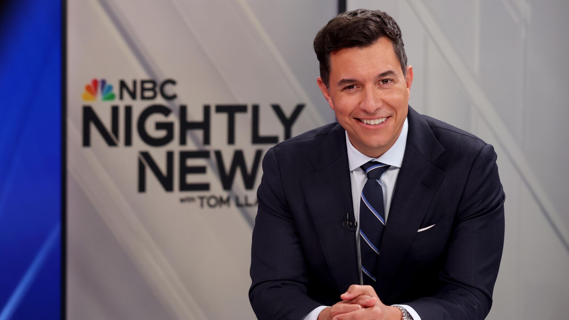 Anchor Tom Llamas at a news desk with NBC Nightly News sign in background
