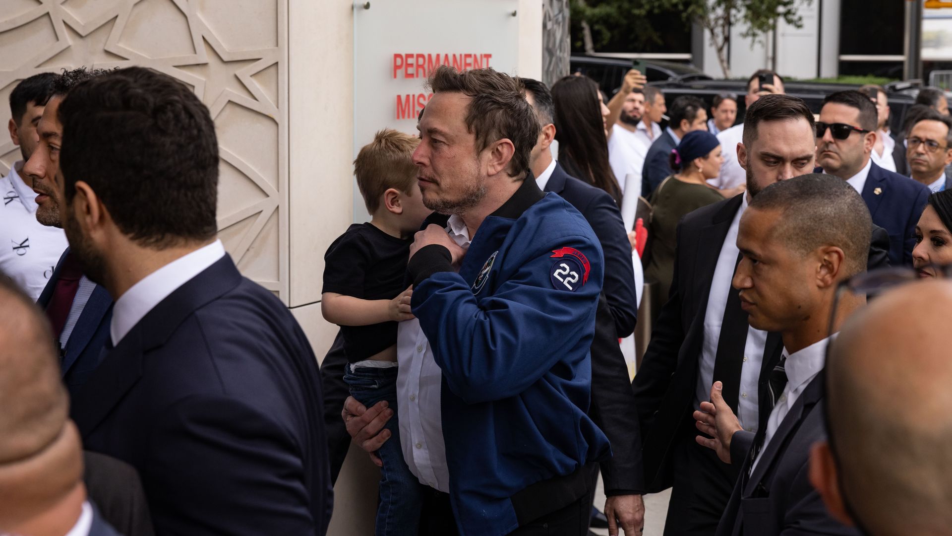 Elon Musk holding his son as they make their way into the Turkish House in New York City