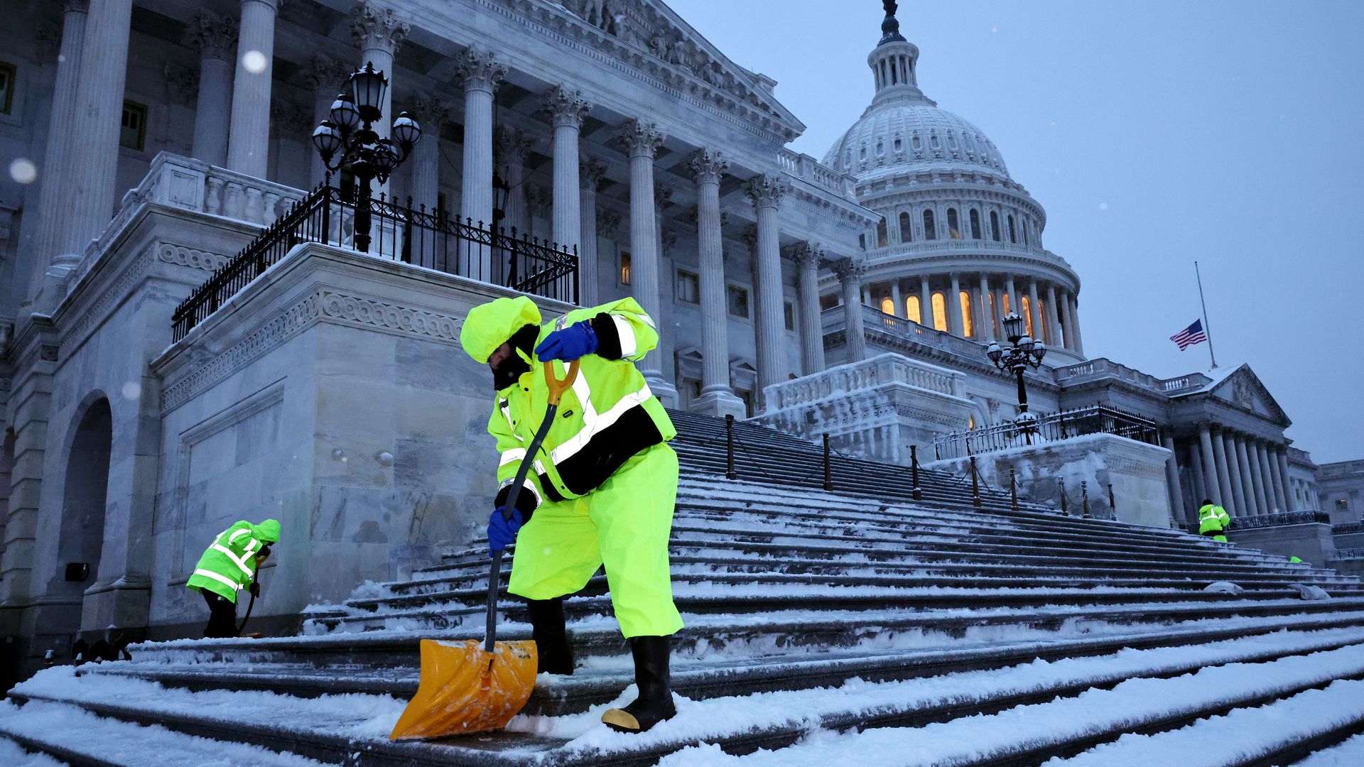 Crews shovel snow on the U.S. Capitol steps.
