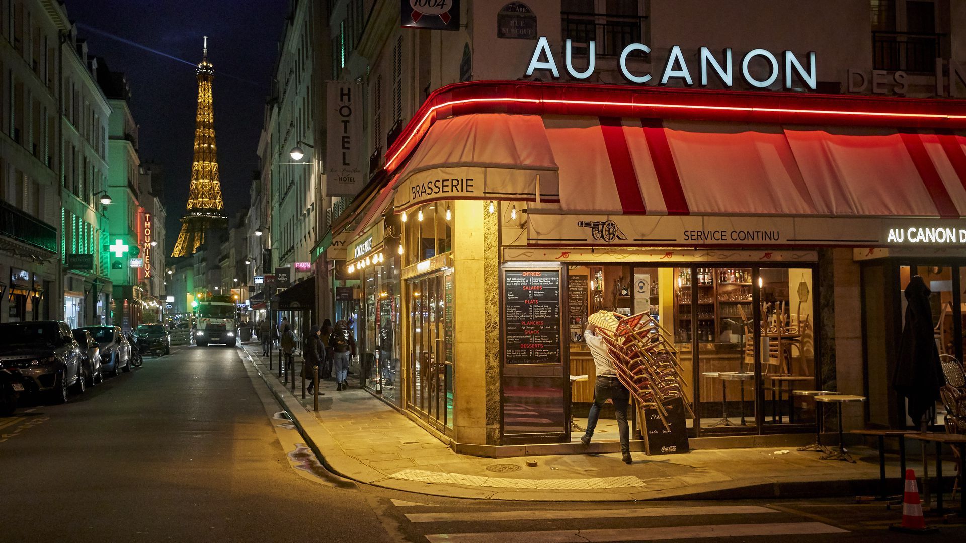 A bar owner closes up before the citywide 9 p.m. to 6 a.m. curfew comes into effect on Oct. 17 in Paris.