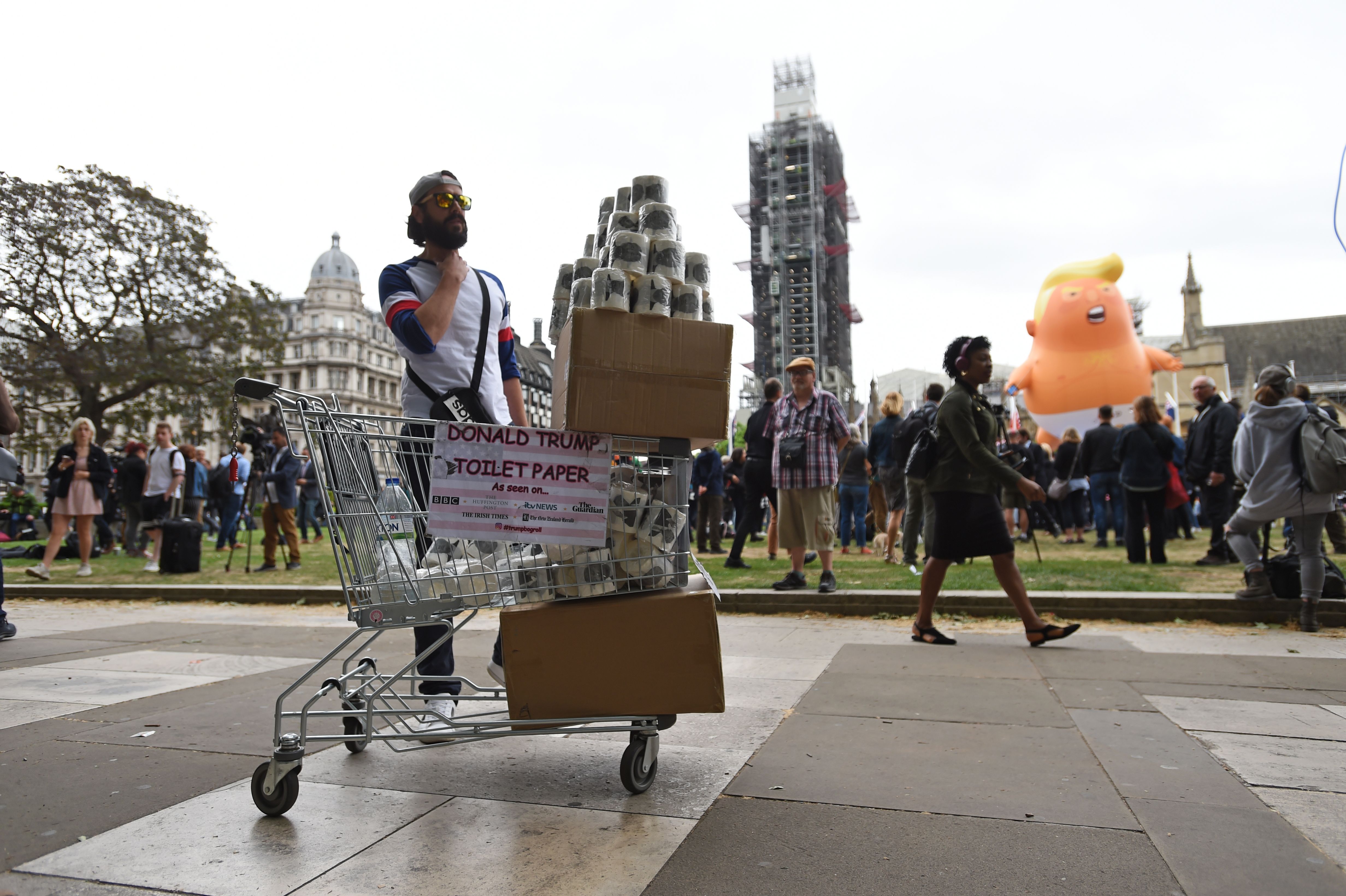 A man sells Donald Trump toilet paper by the Baby Trump Balloon during protests in Parliament Square, London on the second day of the state visit to the UK by US President Donald Trump.