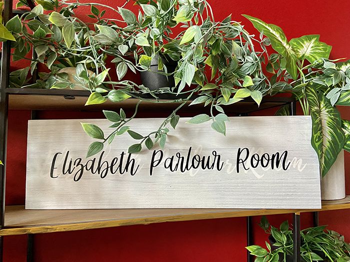 A plant wall with a sign reading, "Elizabeth Parlour Room." 