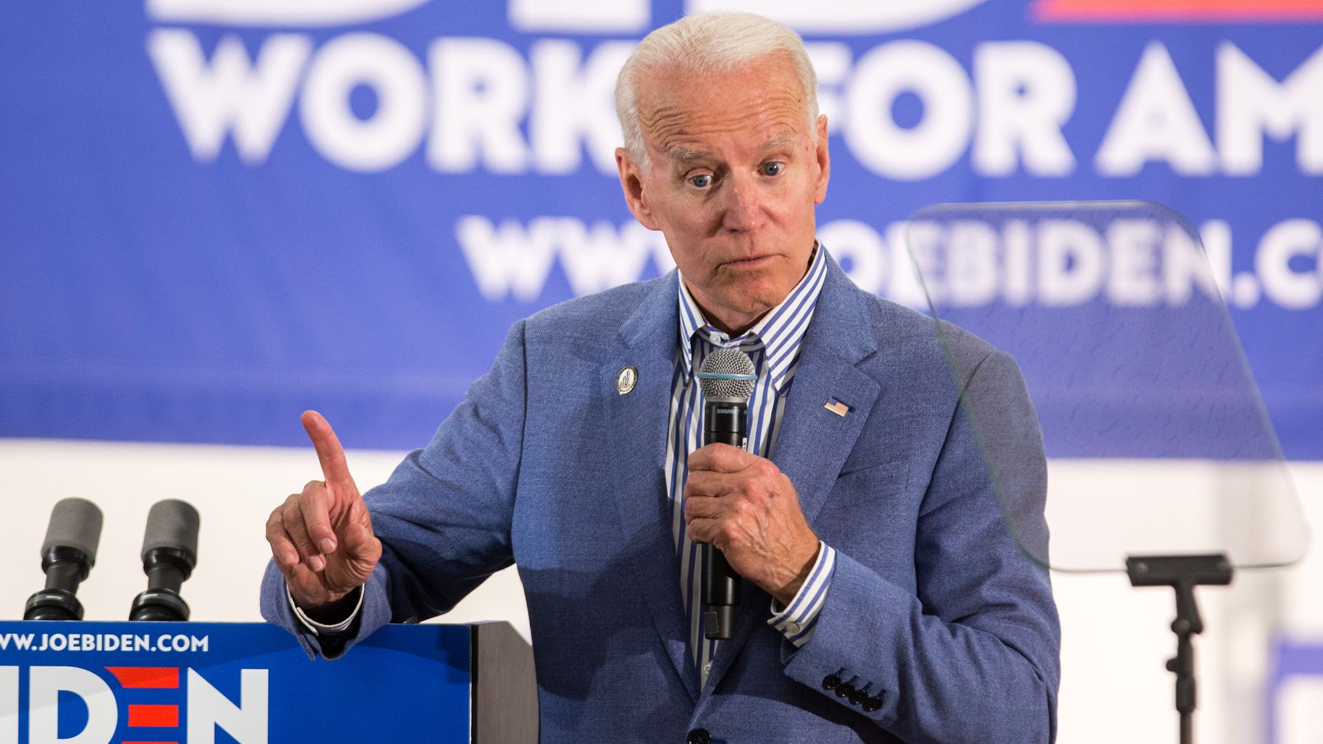 Biden speaking into a microphone and waving his finger.