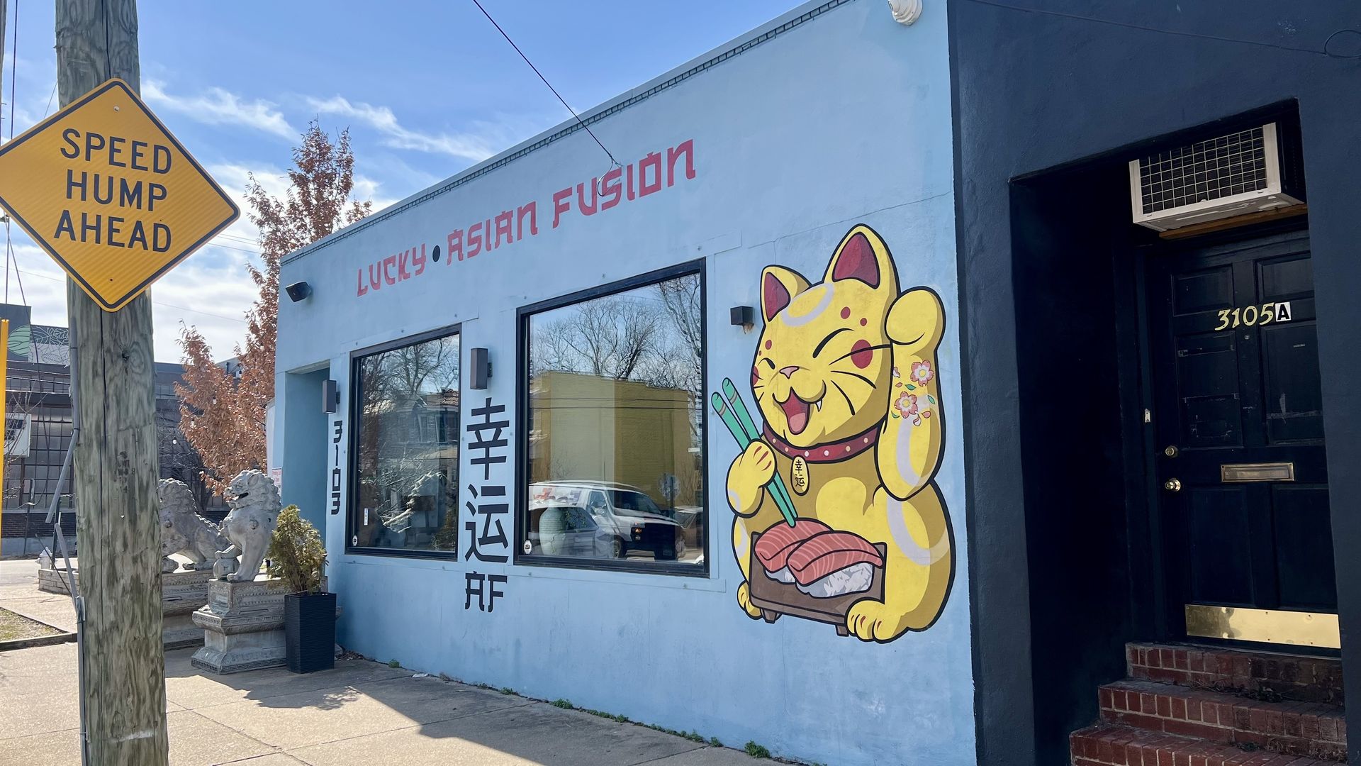 A white building with a happy cat on it