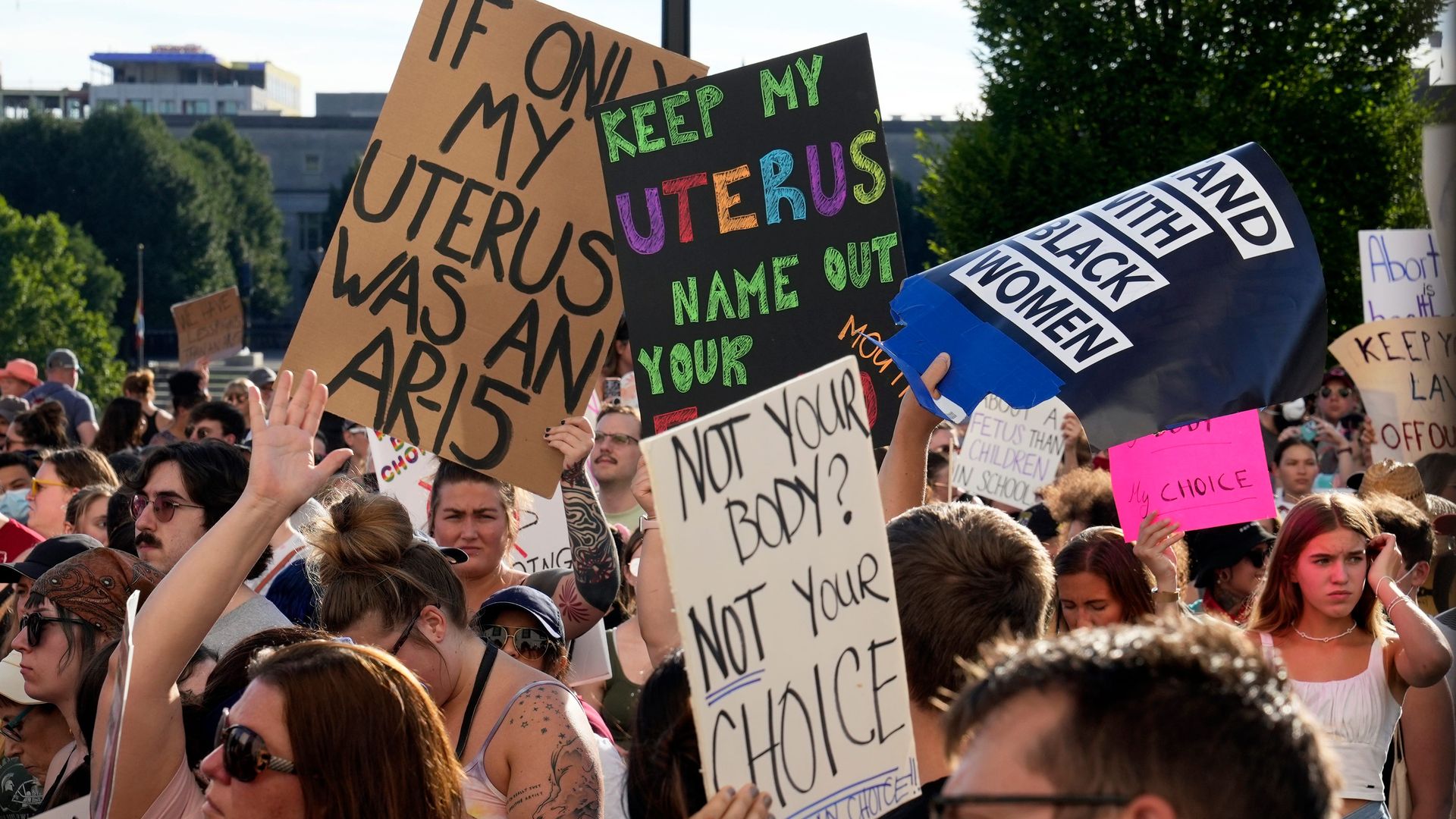 Protesters hold signs condemning the overturning of Roe v. Wade.