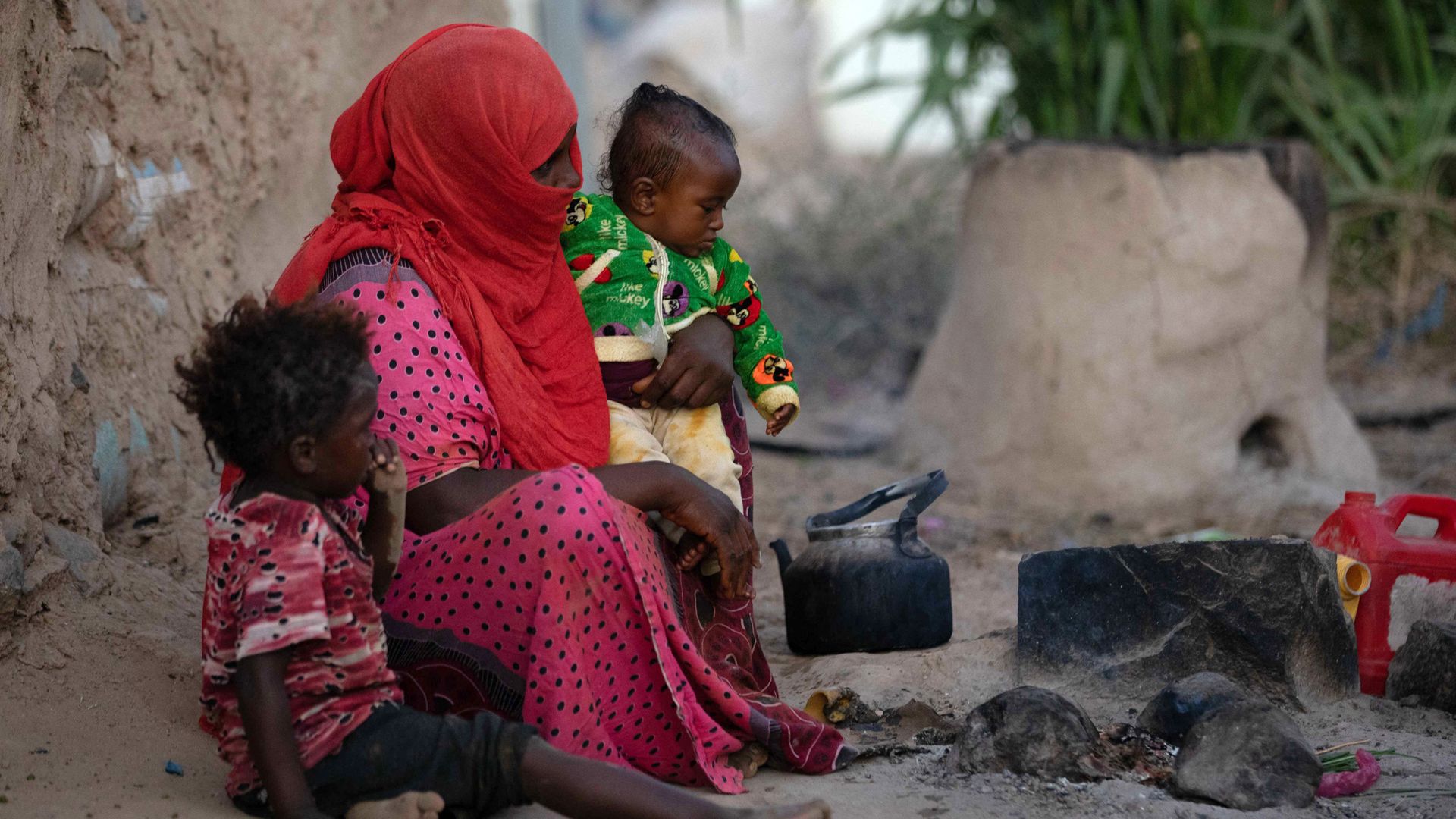 People warm by a fire at a camp for the displaced on the outskirts of Yemen's third city of Taez, on January 11, 2022. (Photo by AHMAD AL-BASHA / AFP) 