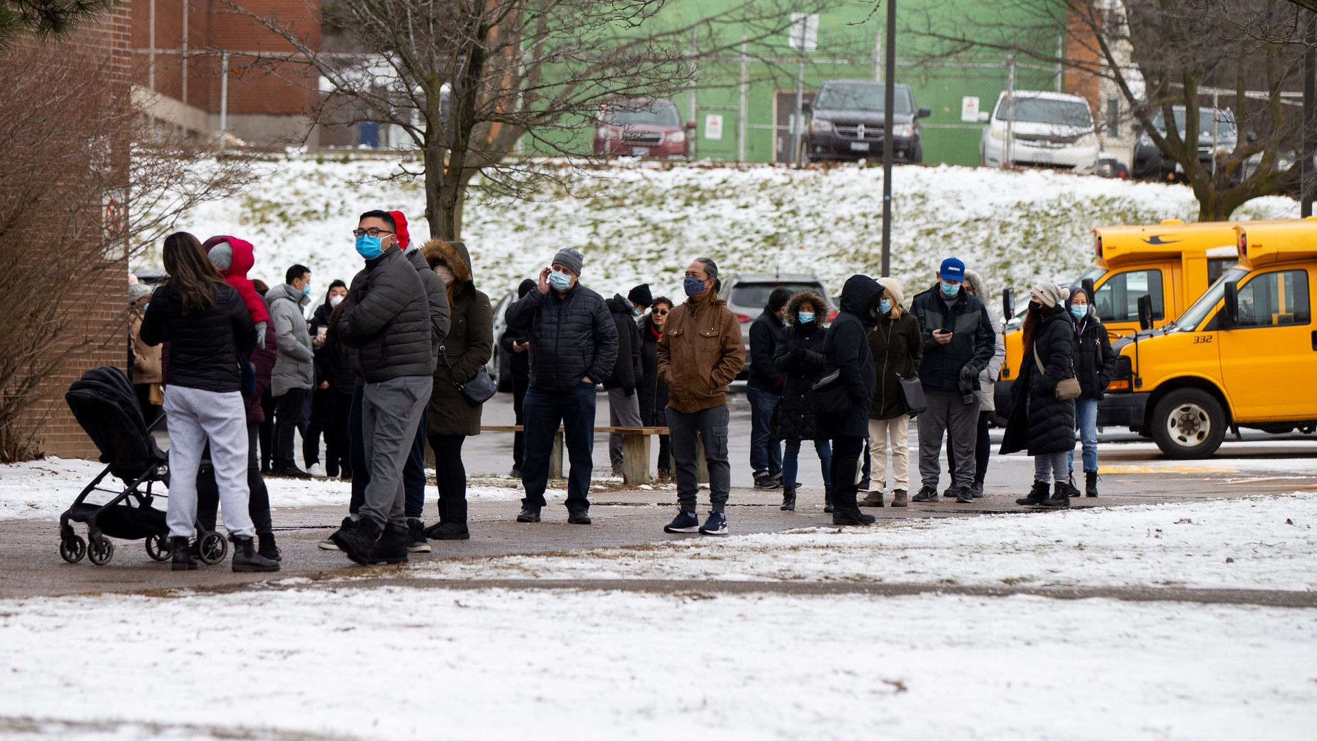 People wearing face masks line up to enter a COVID-19 vaccination clinic in Toronto, Canada