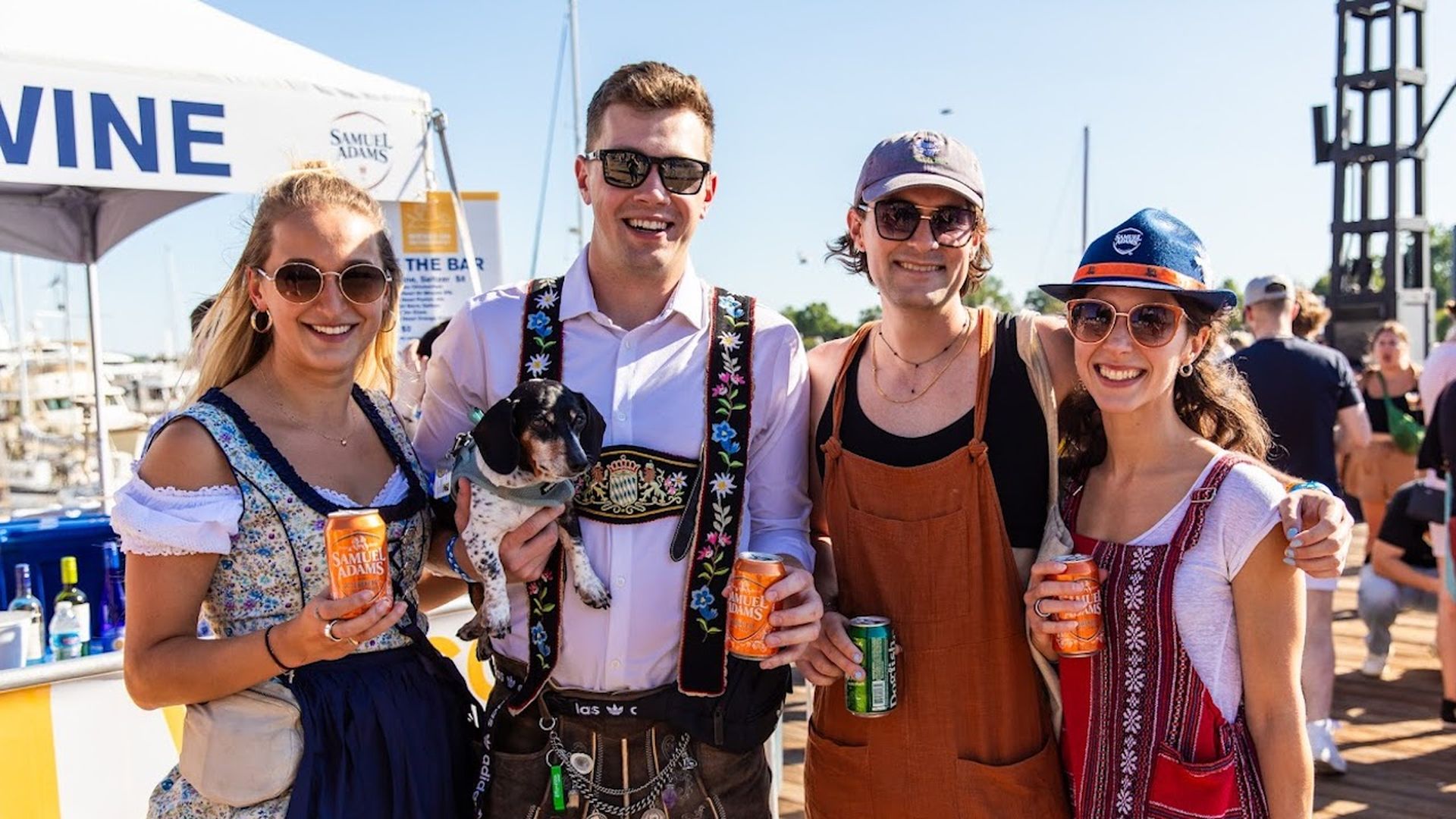 Four people in Oktoberfest costumes and a dog at the Wharf