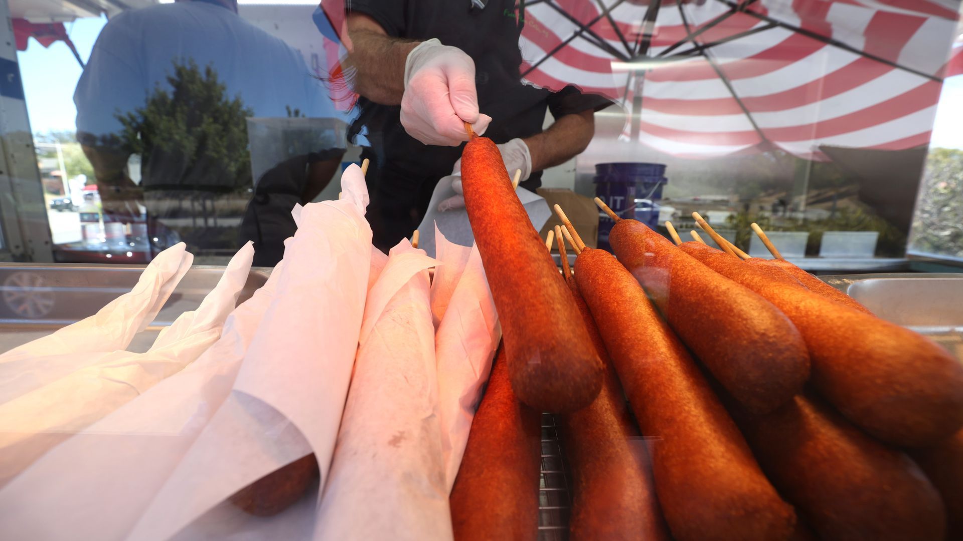 A row of corndogs, with some wrapped in paper