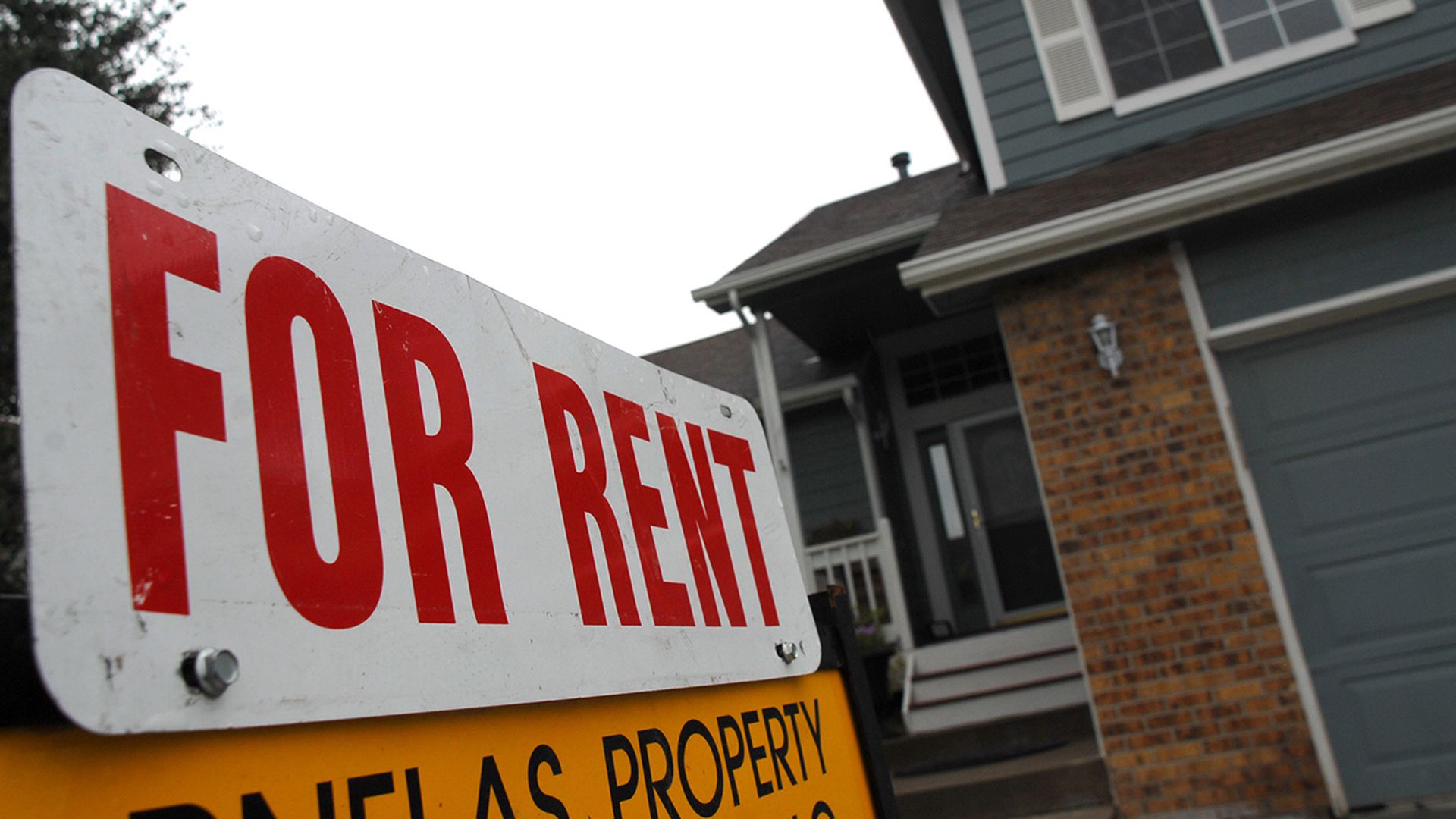 home for rent sign in front of a house