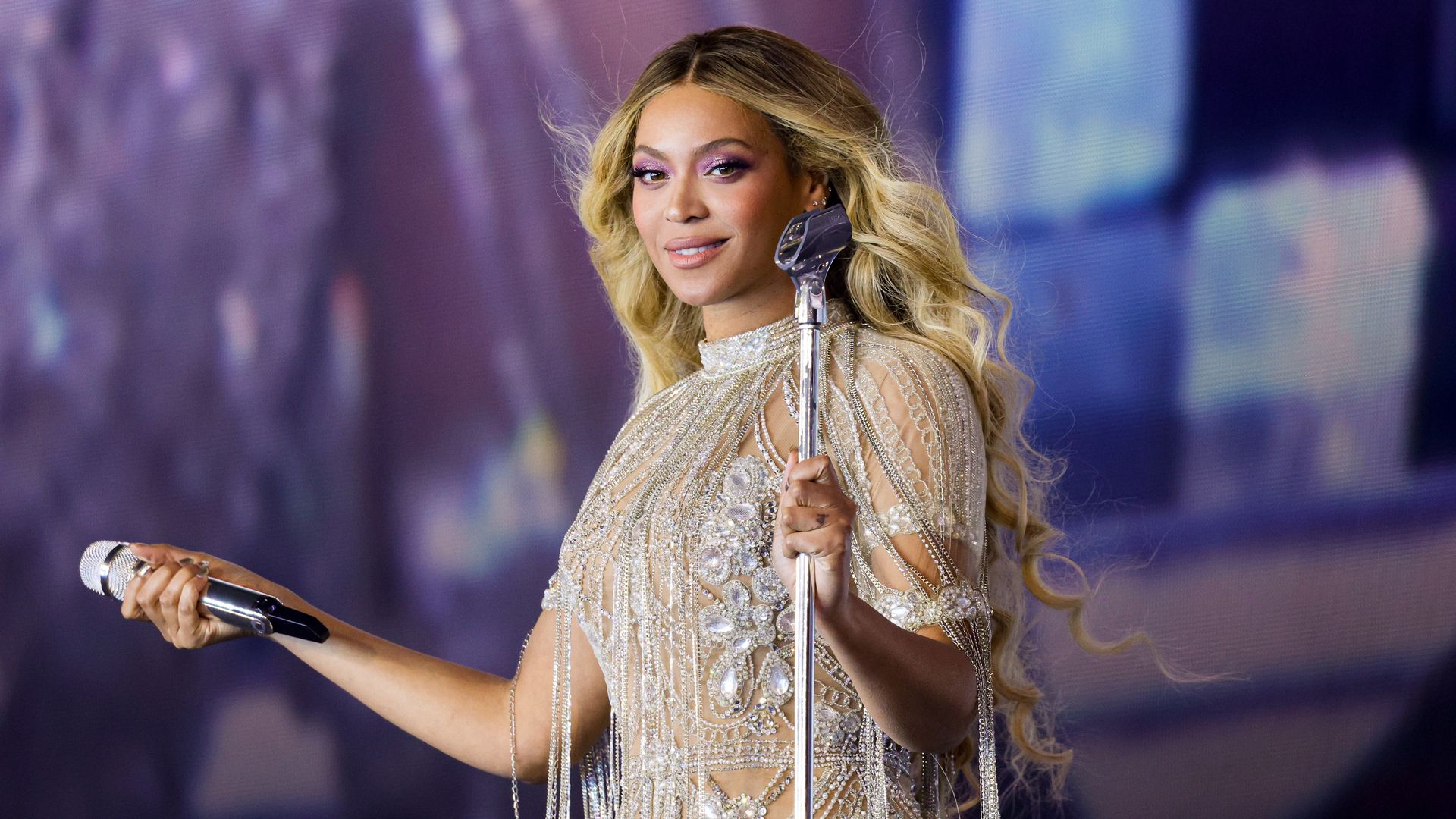 Beyonce stands on stage holding a microphone