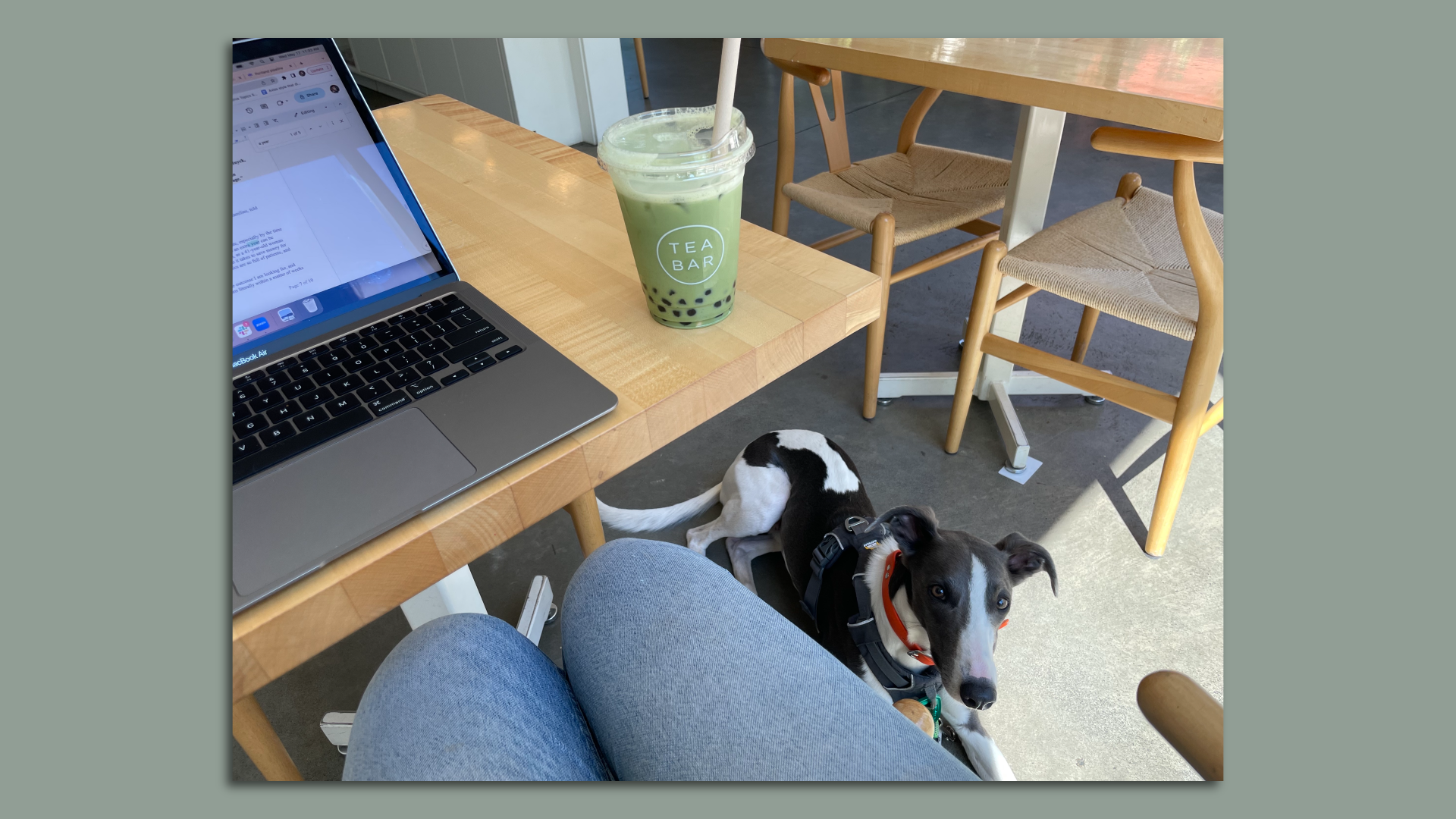 A photo of a matcha milk tea with boba sitting on a table.