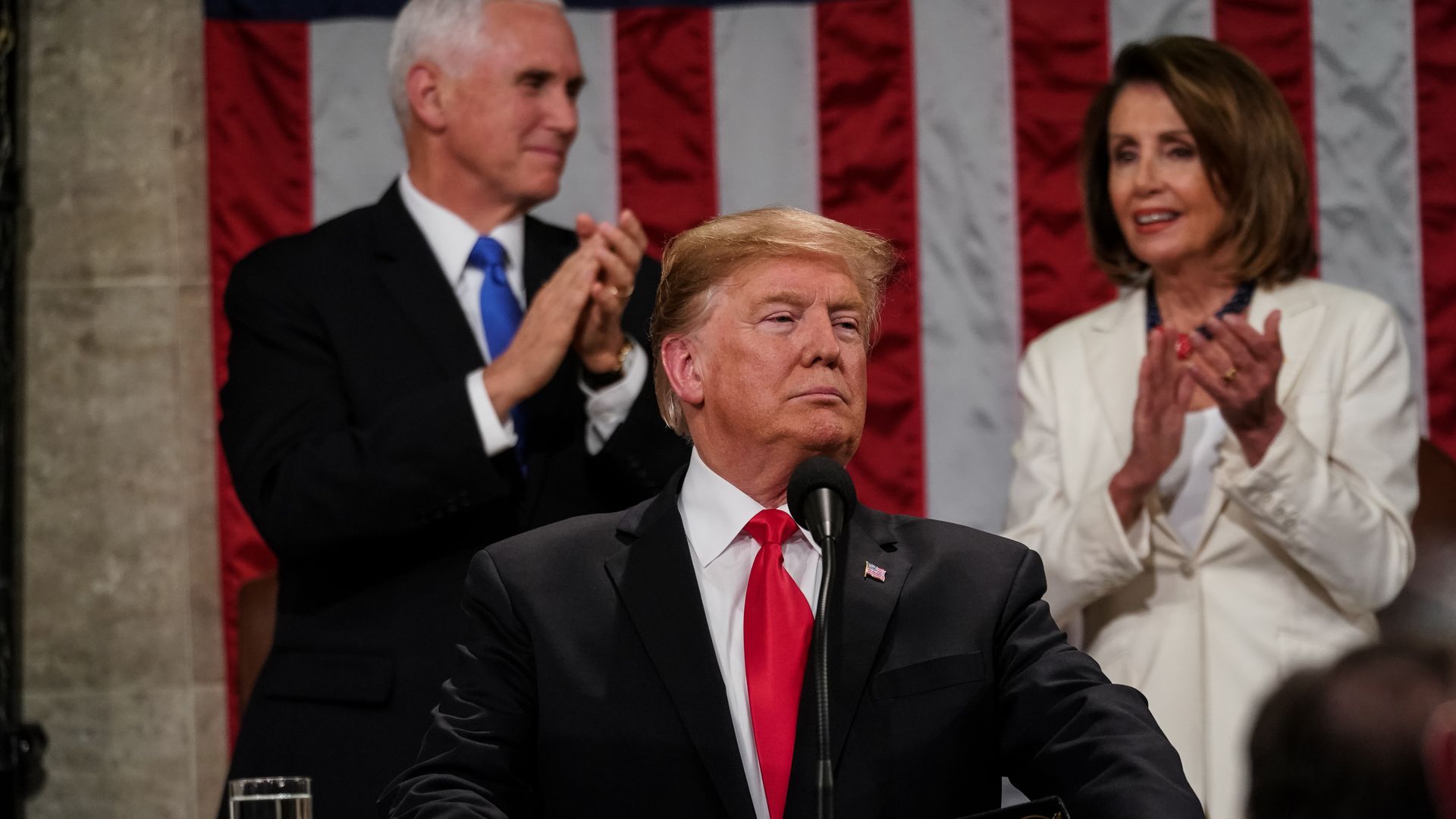 The president, with the Vice President and the Speaker of the House behind him